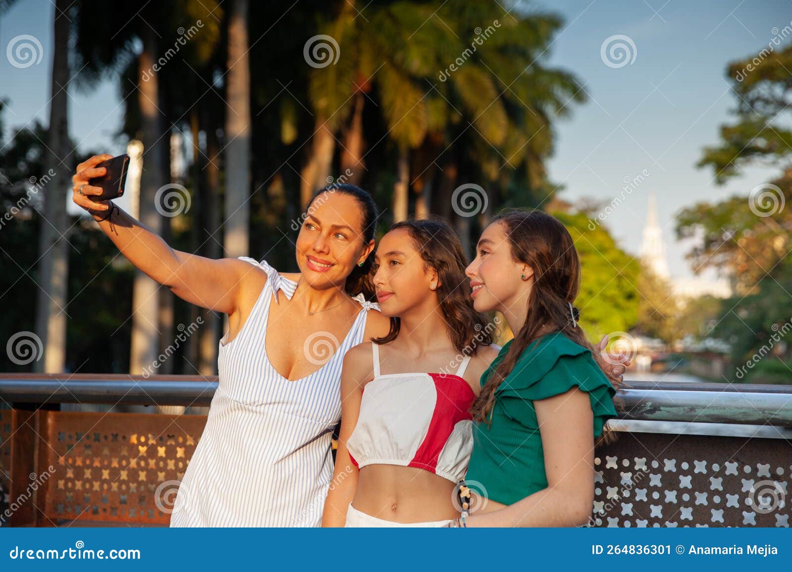 tourists taking a selfie in one of the bridges along the cali river boulevard with la ermita church on background in the city of