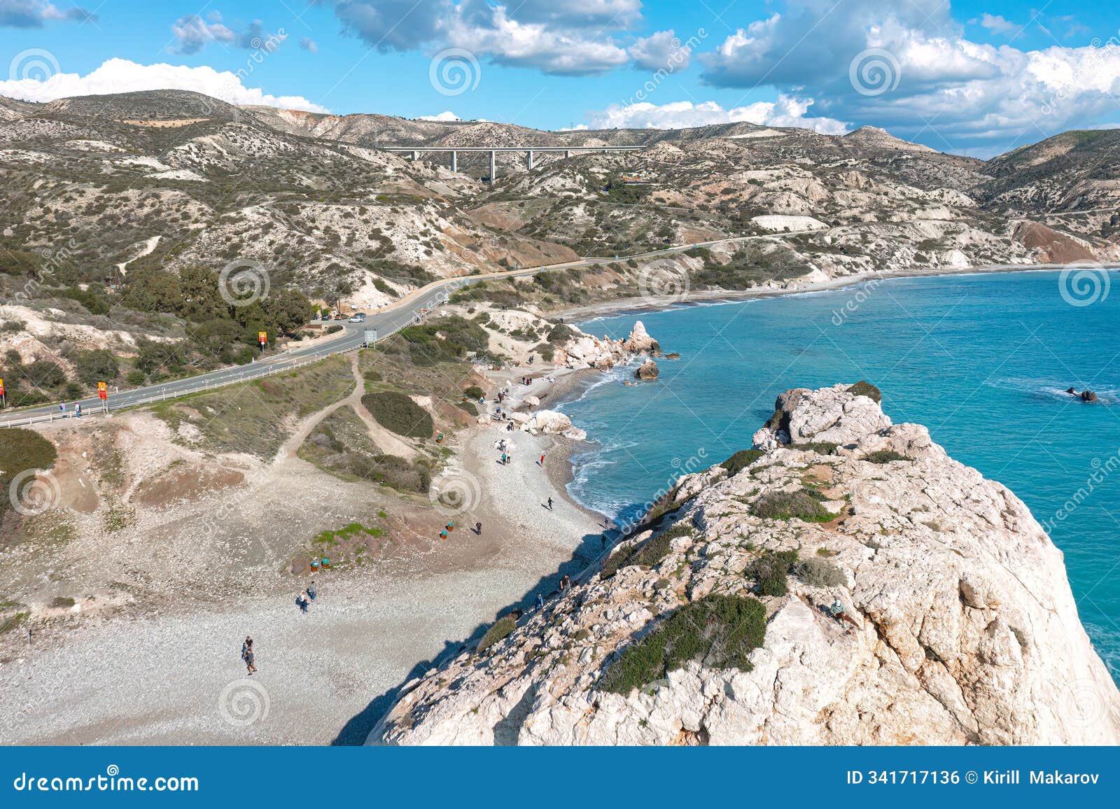 tourists walking on aphrodite's rock beach in cyprus