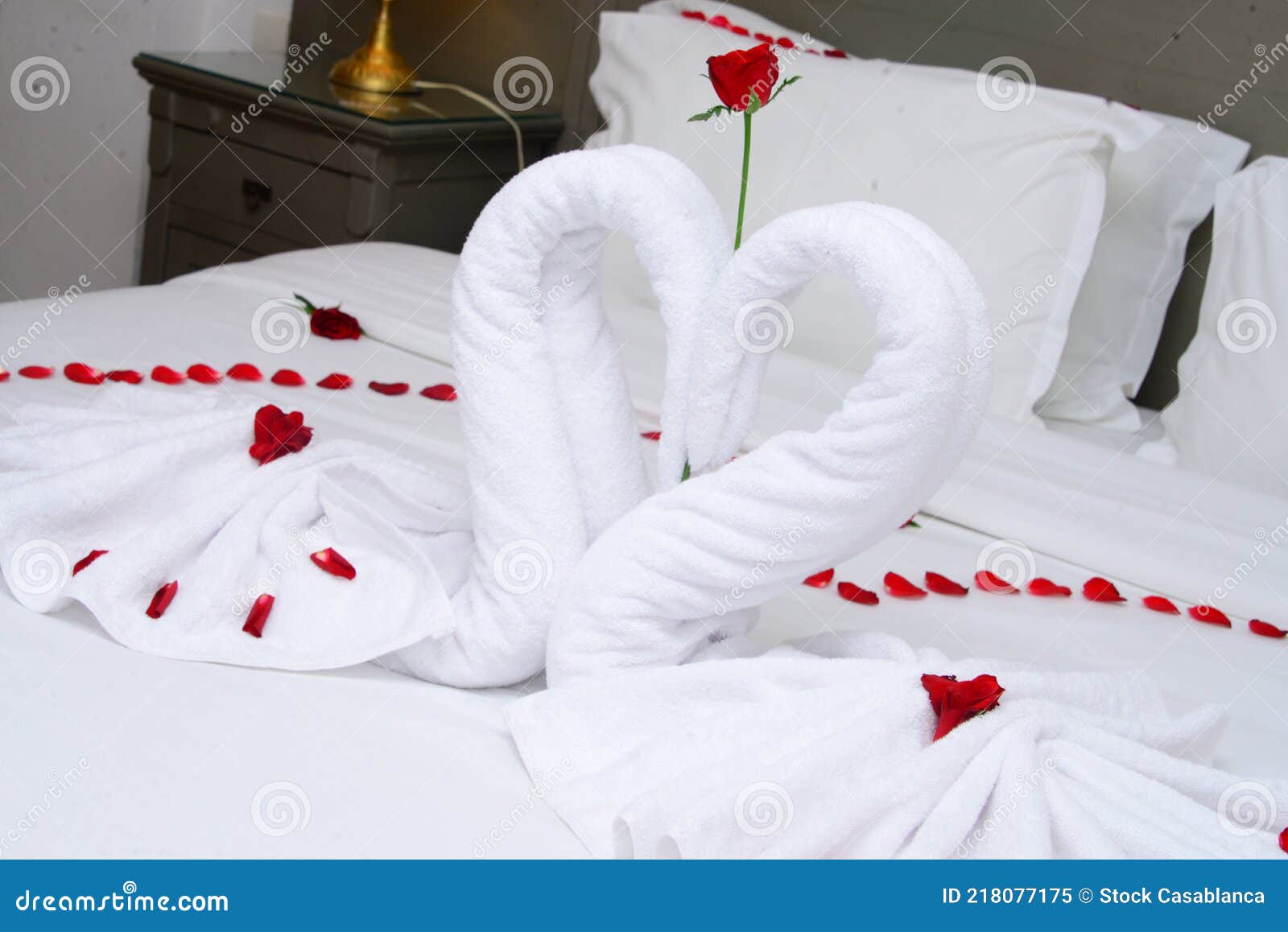 Towel As Birds Decoration with Red Rose Petals on White Clean Bed ...