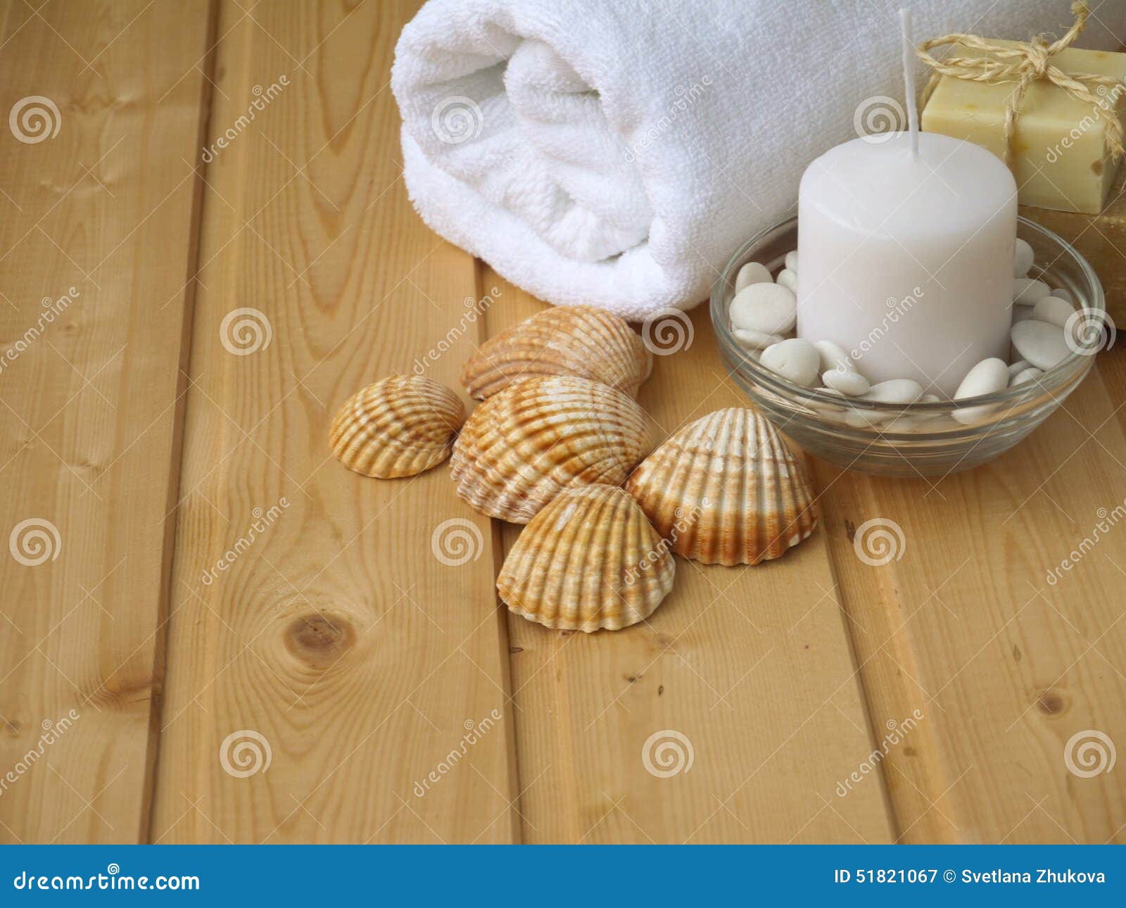Towel,soap,candle and shells on the wooden background