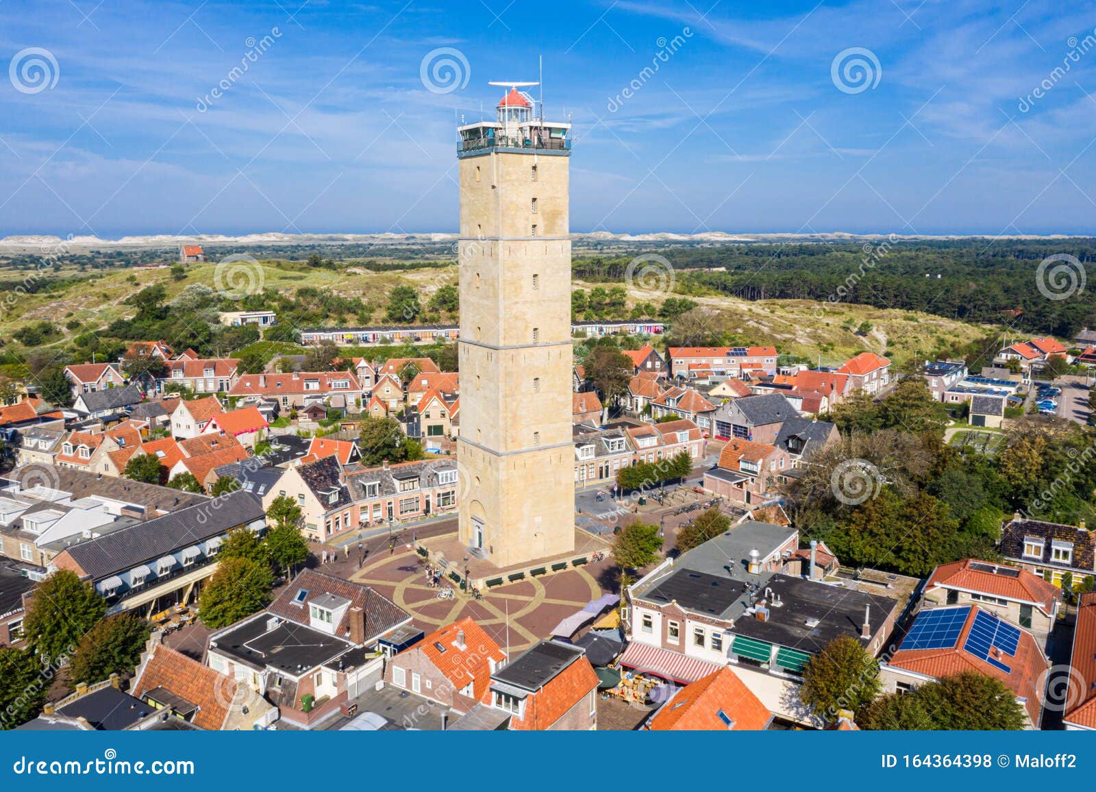 the tower of old brandaris lighthouse among historical houses around the central square of west-terschelling town. terschelling