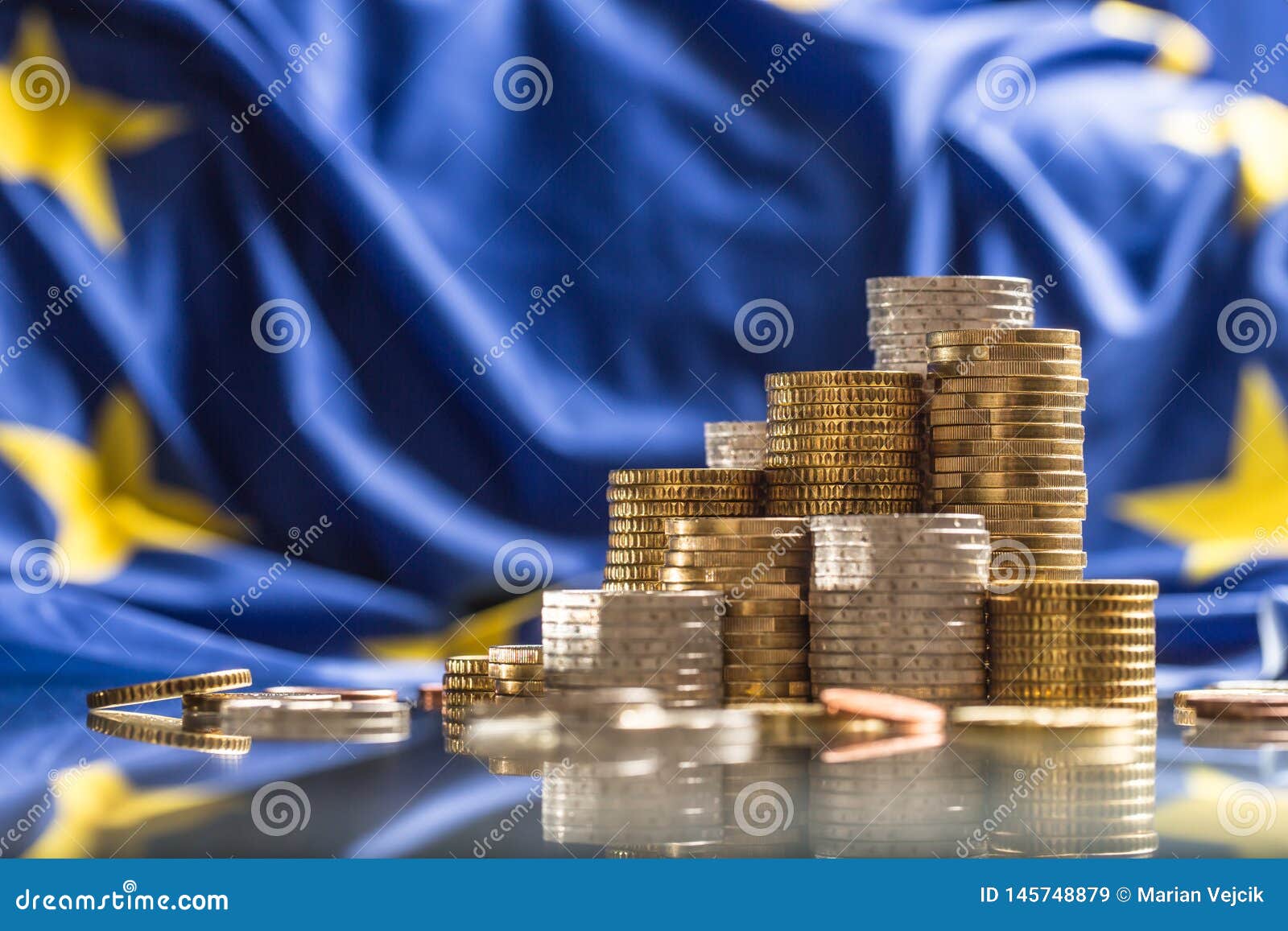 towers with euro coins and flag of european union in the background