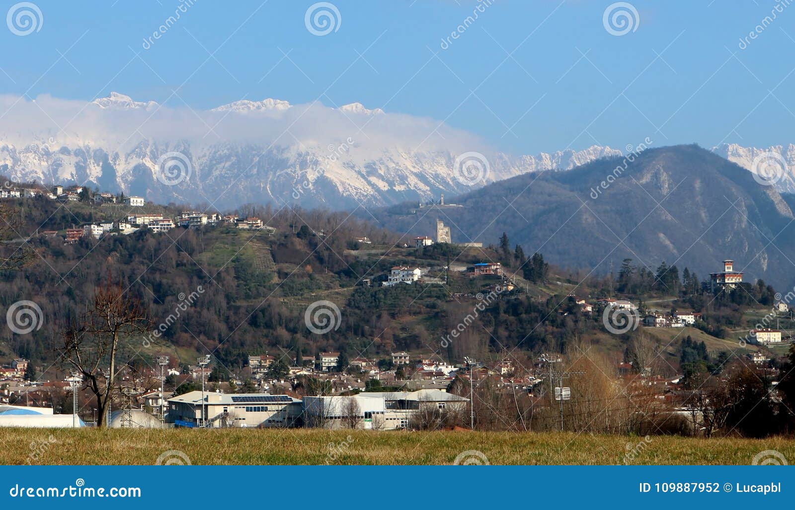 townscape of tarcento, near udine in italy, on its hills. on background the snowed julian alps