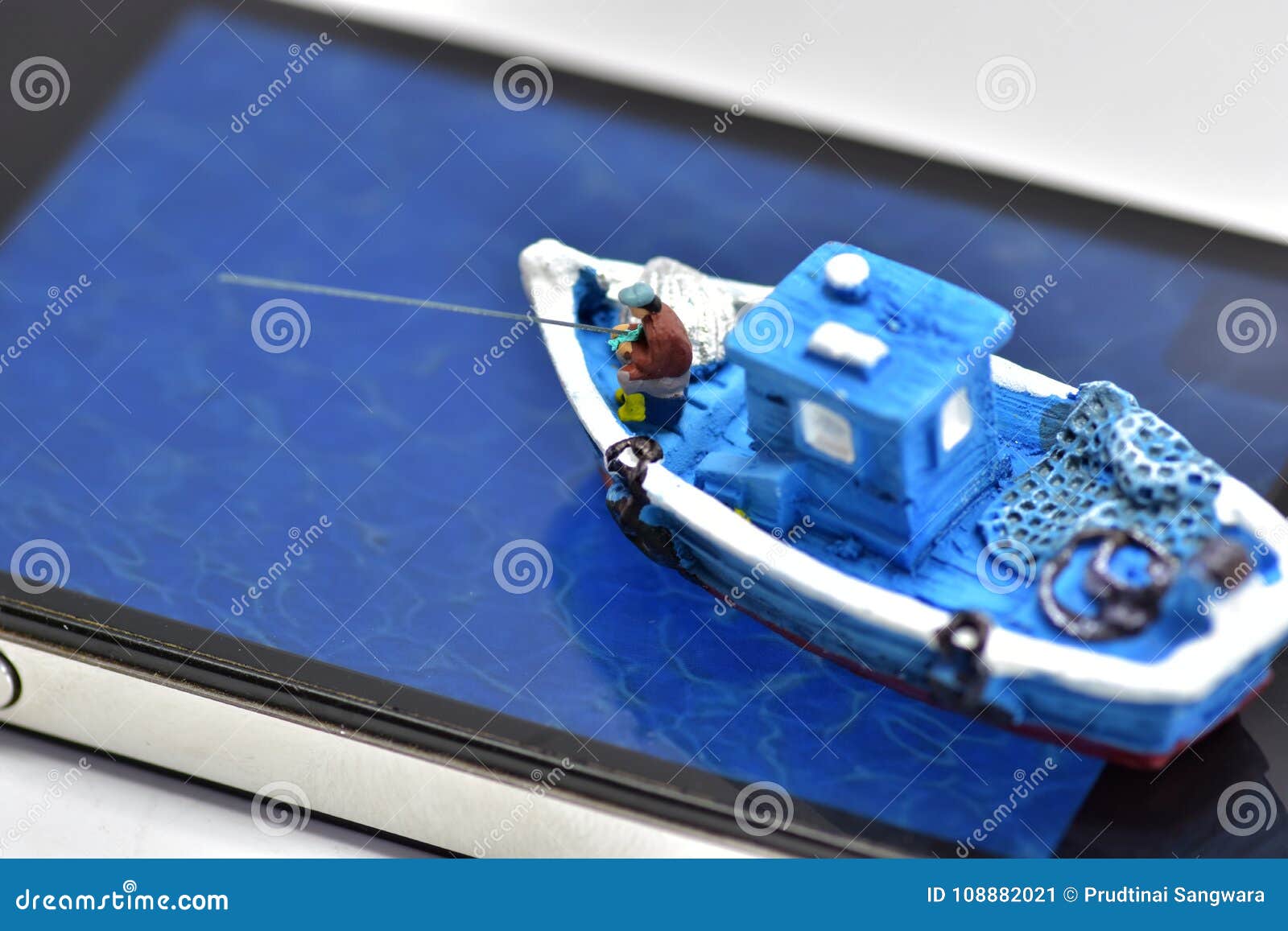 Toy Boat with Fishermen on Smartphone Stock Image - Image of