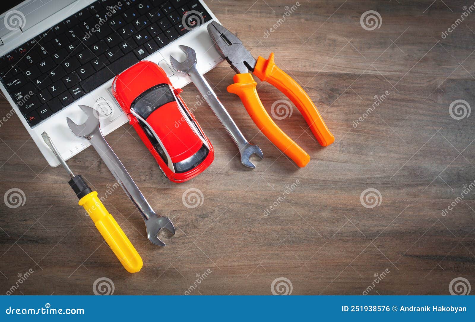 Toy Car, Wrench, Screwdriver, Pliers on the Computer Keyboard Stock