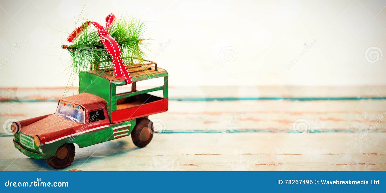 toy tempo carrying christmas fir on wooden plank