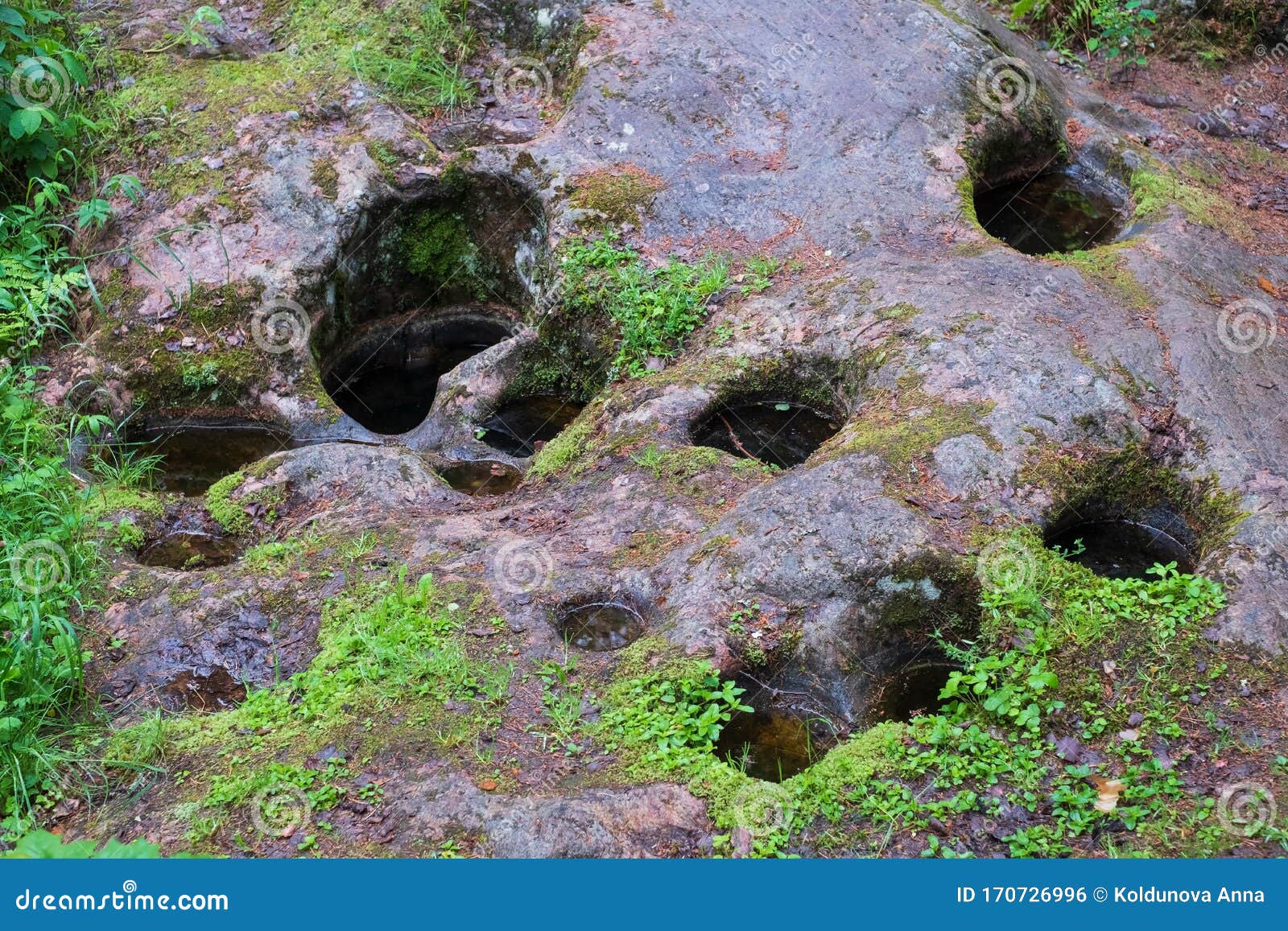Traces from Water in Stone. Round Holes in Granite in Forest Stock