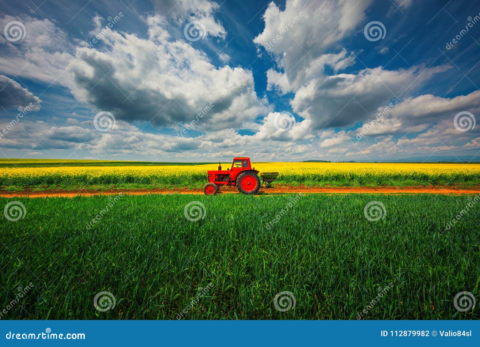 tractor in the agricultural fields and dramatic clouds