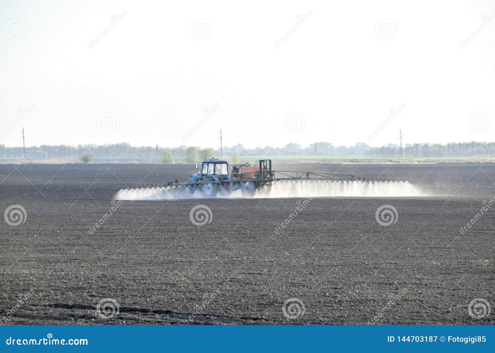 The tractor sprayed herbicides on the field. Chemistry in agriculture