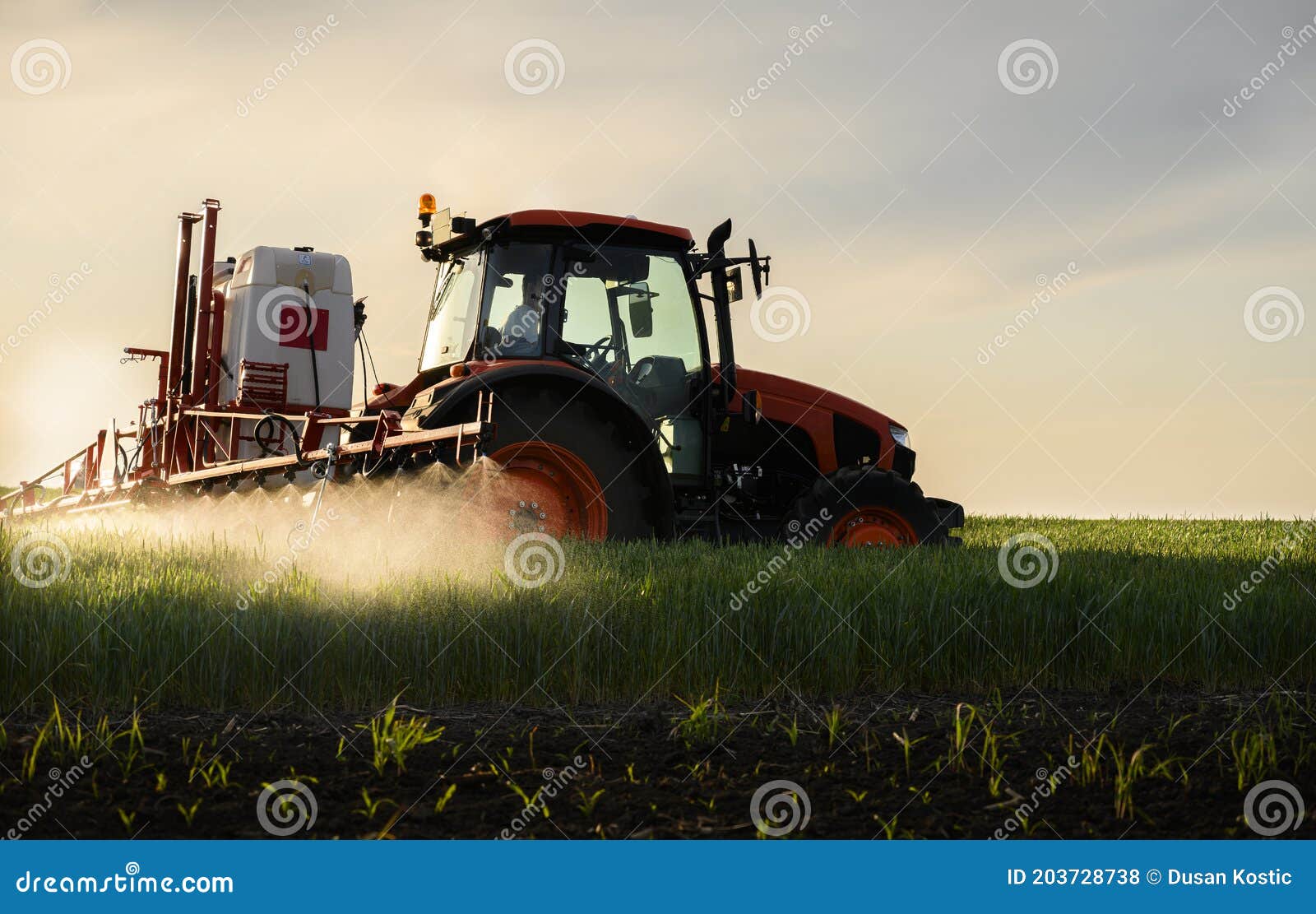 tractor spraying pesticides wheat field