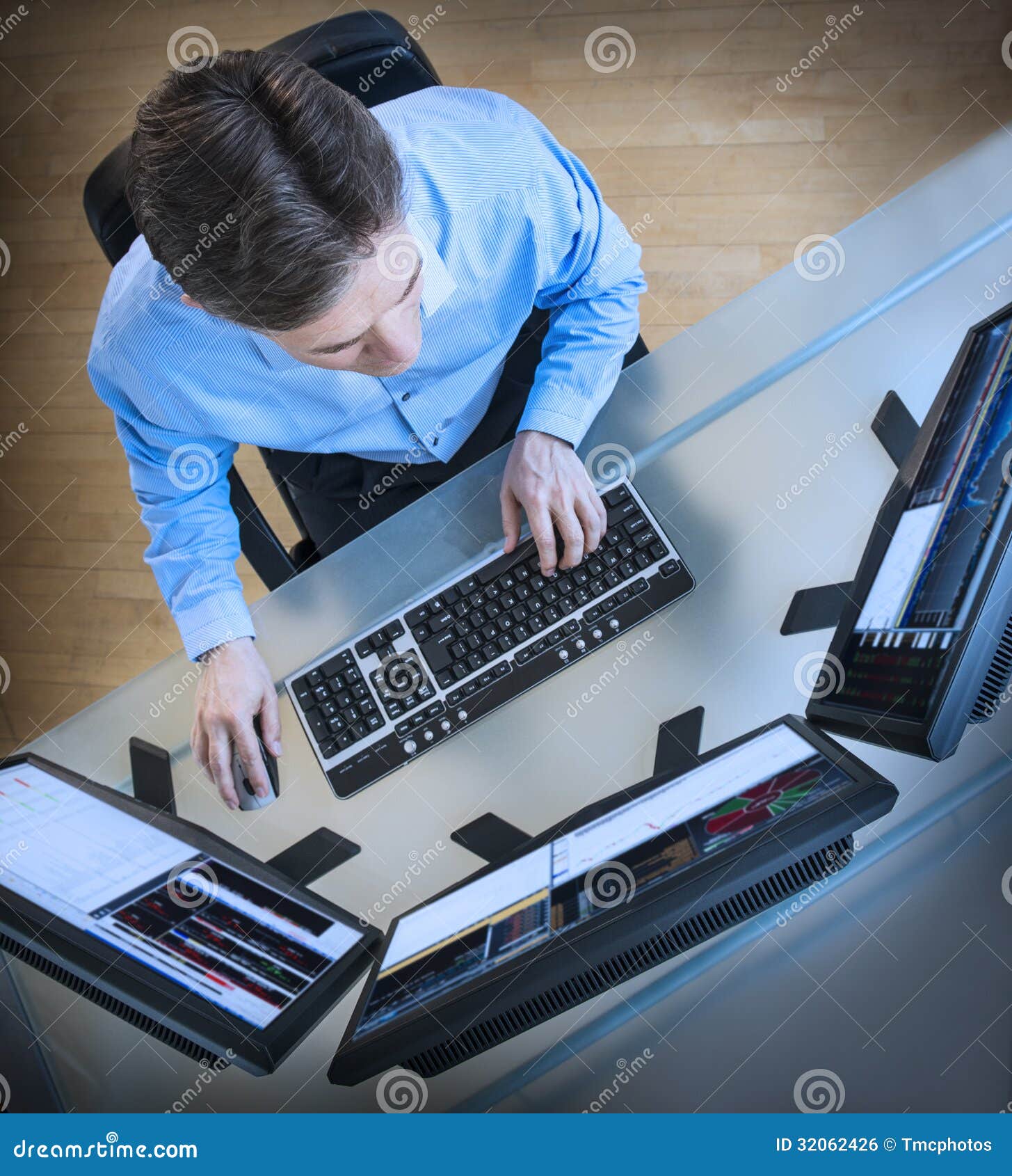 trader analyzing data on multiple screens at desk