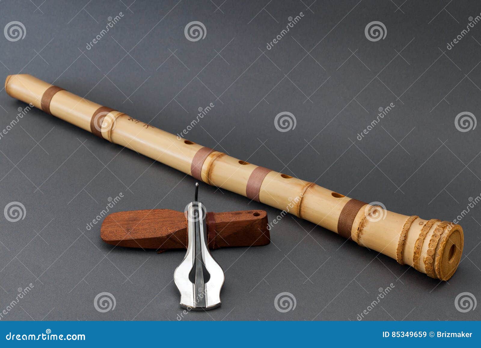 traditional bamboo japanese flute with jew`s harp on gray background.