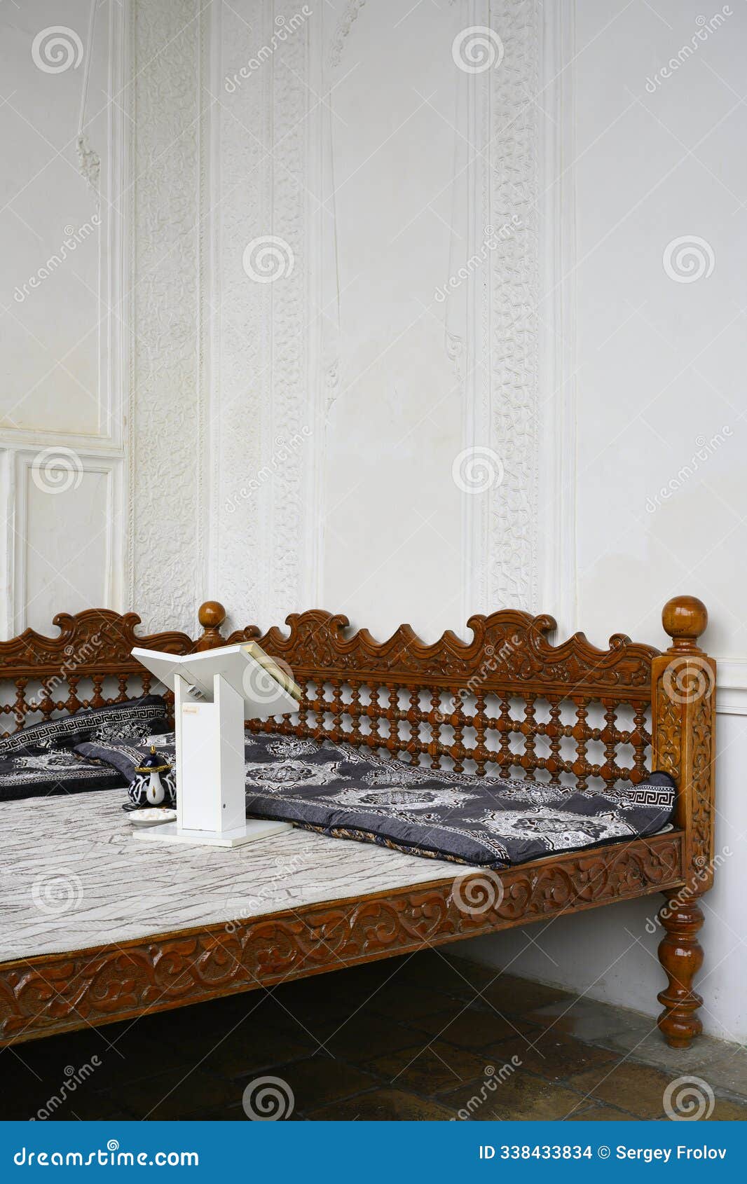 traditional central asian carved wooden cot with book stand and kettle in shahi zinda in samarkand, uzbekistan