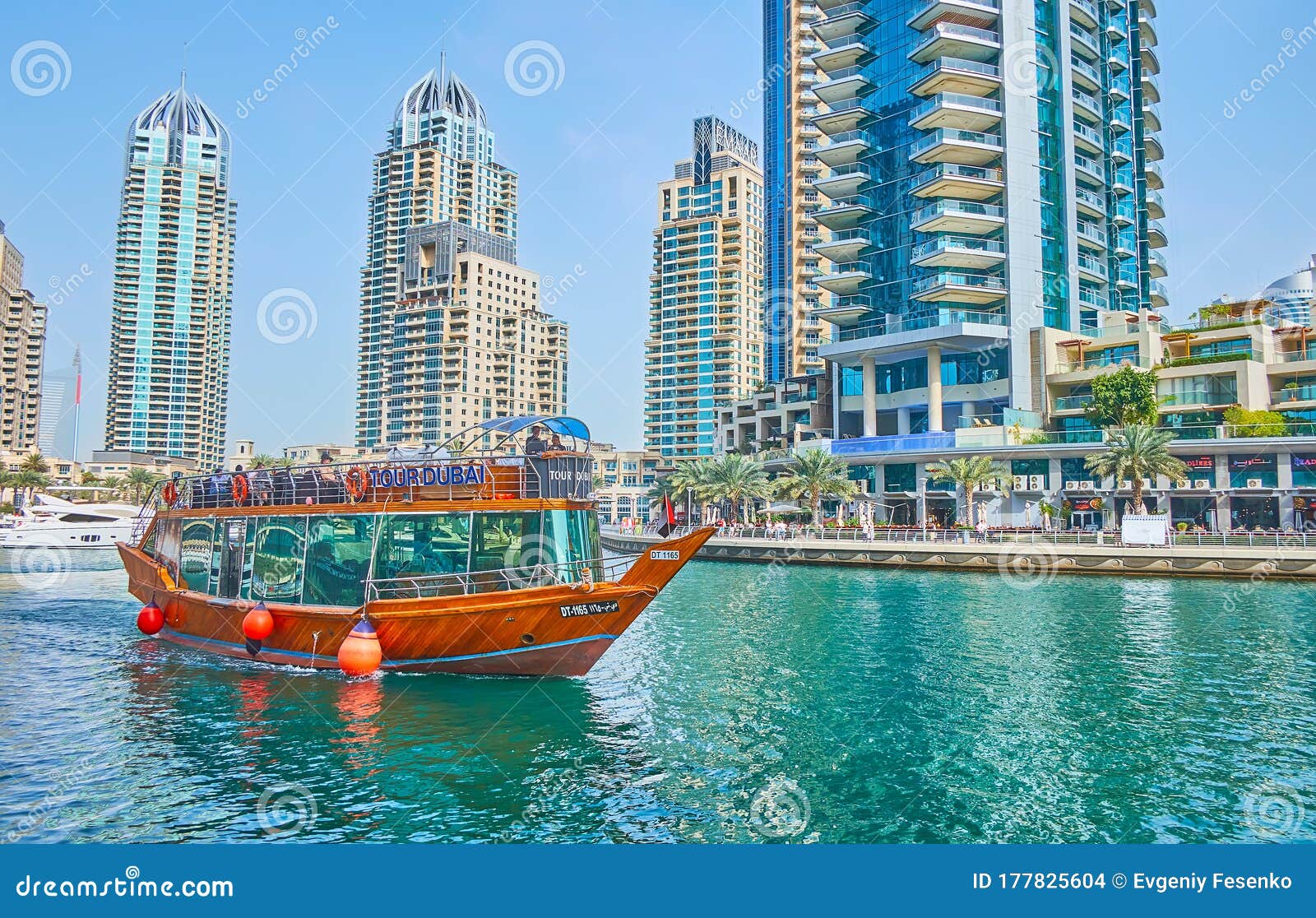 Traditional dhow boat in Dubai Marina, UAE. DUBAI, UAE - MARCH 2, 2020: Enjoy dhow boat cruise along the modern Dubai Marina, surrounded by luxury living skyscrapers, cozy cafes, restaurants and yacht clubs, on March 2 in Dubai