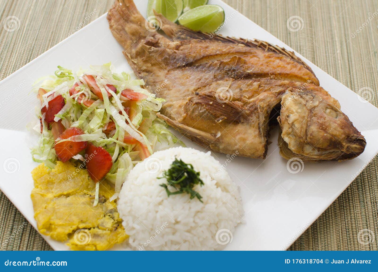 Traditional Fried Fish with Rice, Salad and Fried Plantain Stock Photo