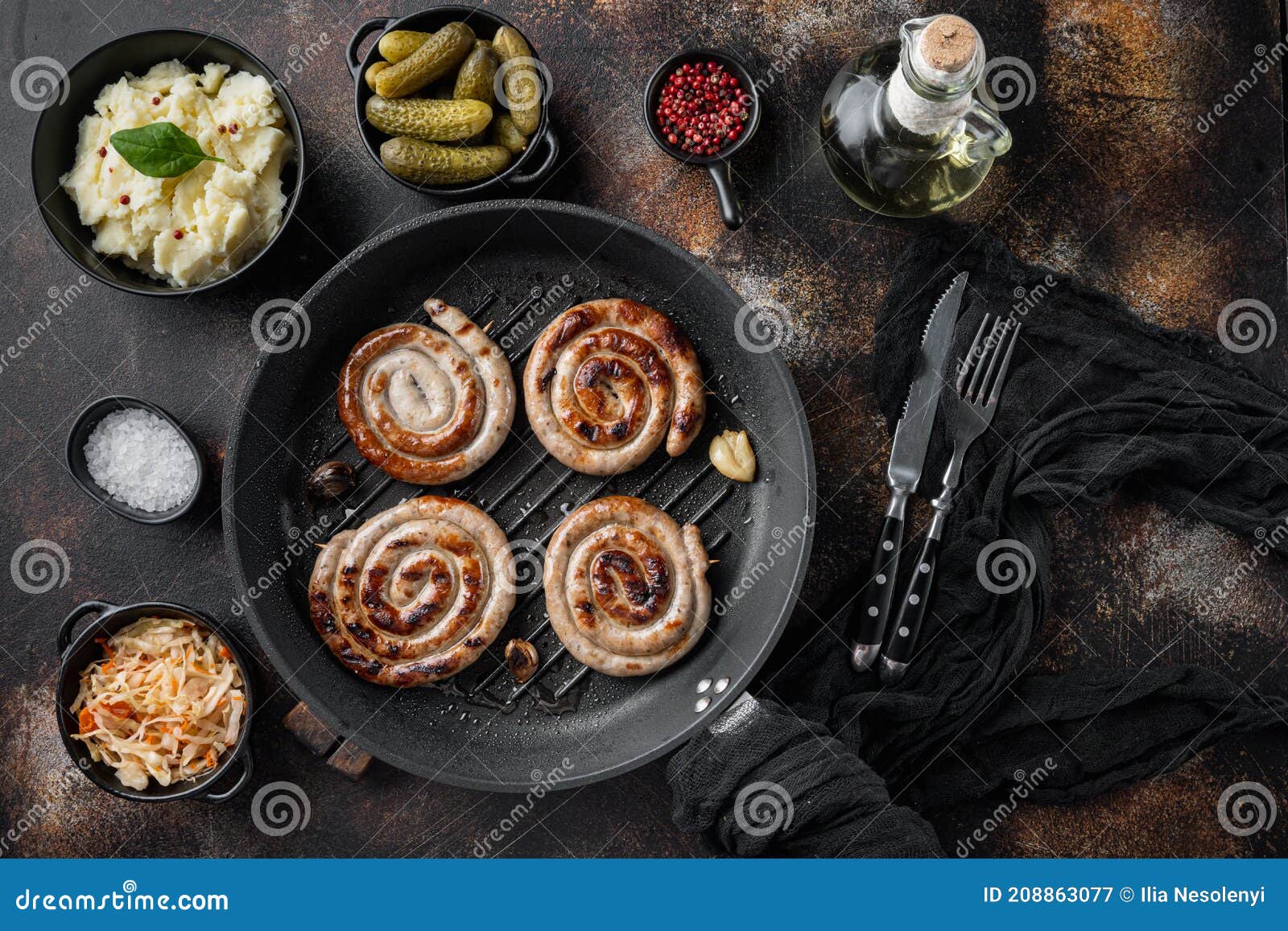 traditional german sausages with mashed potatoes and sauerkraut in cast iron frying pan  on old dark rustic background  top view