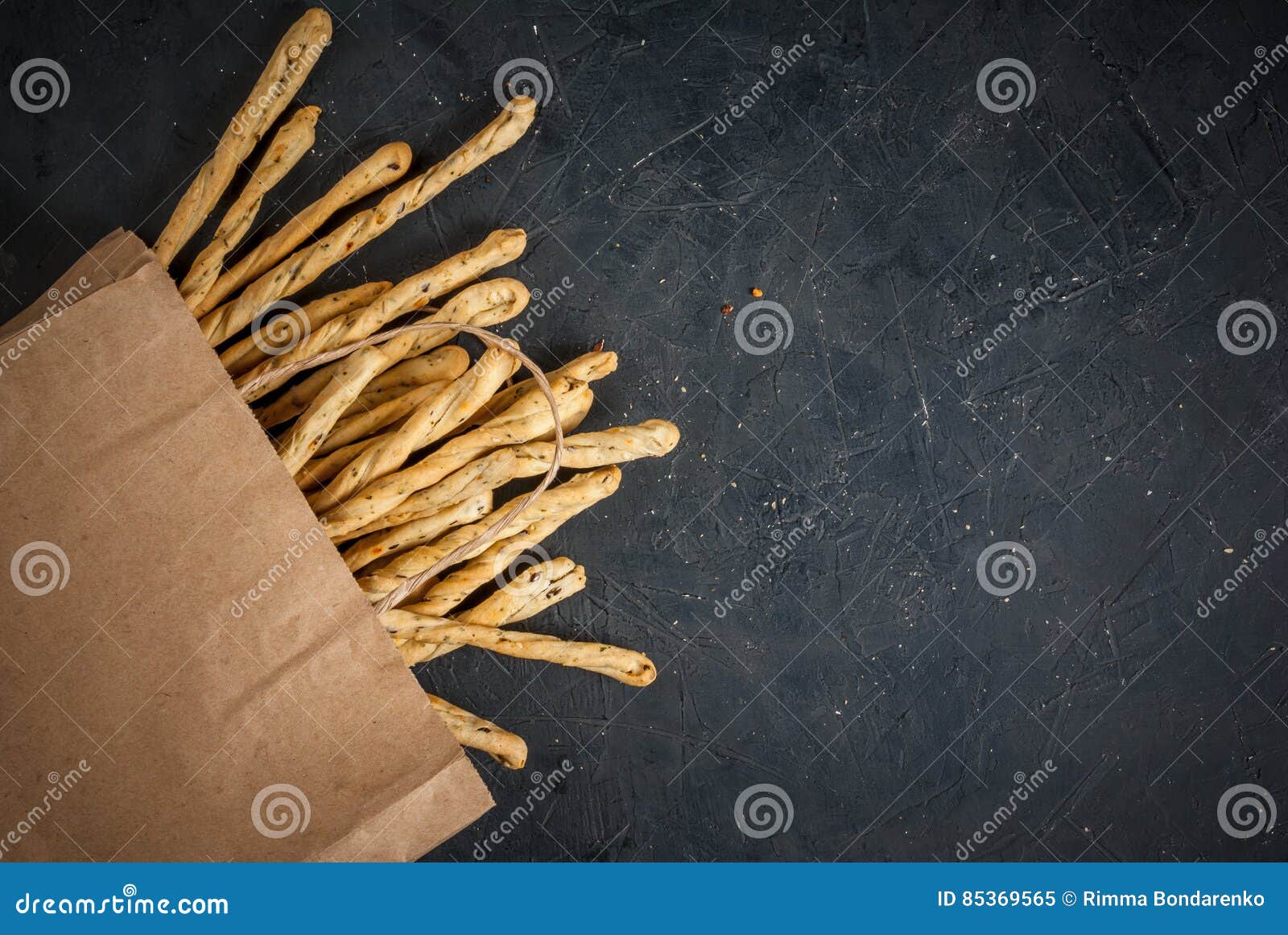 Traditional Italian snack - grissini. Traditional Italian snack, bread - grissini. On a dark stone table, top view, copy spnace