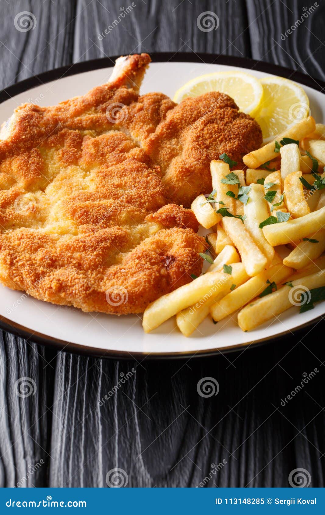 Traditional Italian Veal Milanese with Lemon and French Fries Cl Stock ...