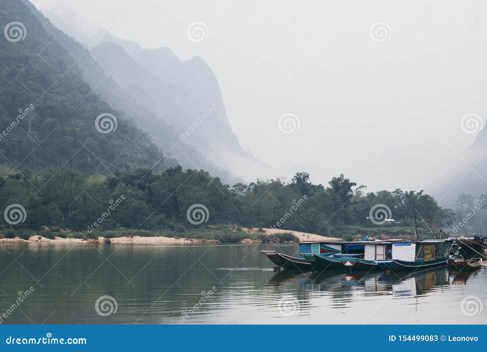 traditional laotian wooden slow boat on nam ou river near nong khiaw village, laos