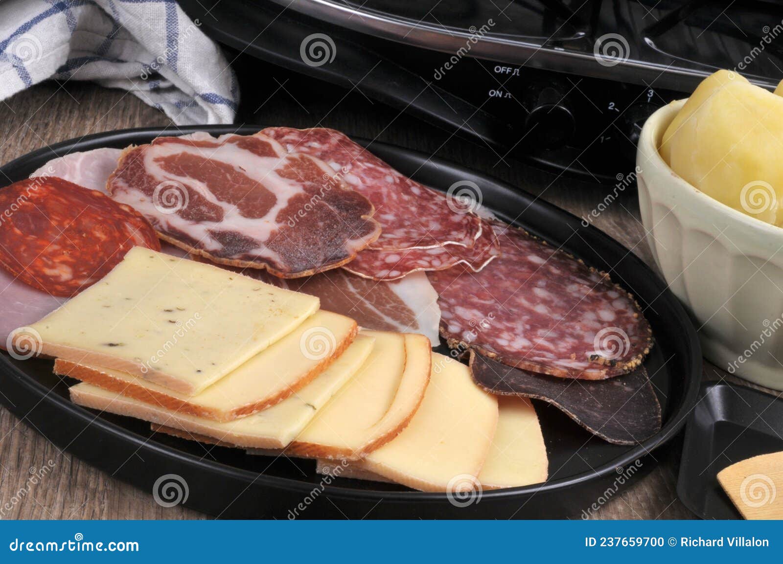 Assortment Of Cold Meats And Cheese Slices To Make A Raclette Stock