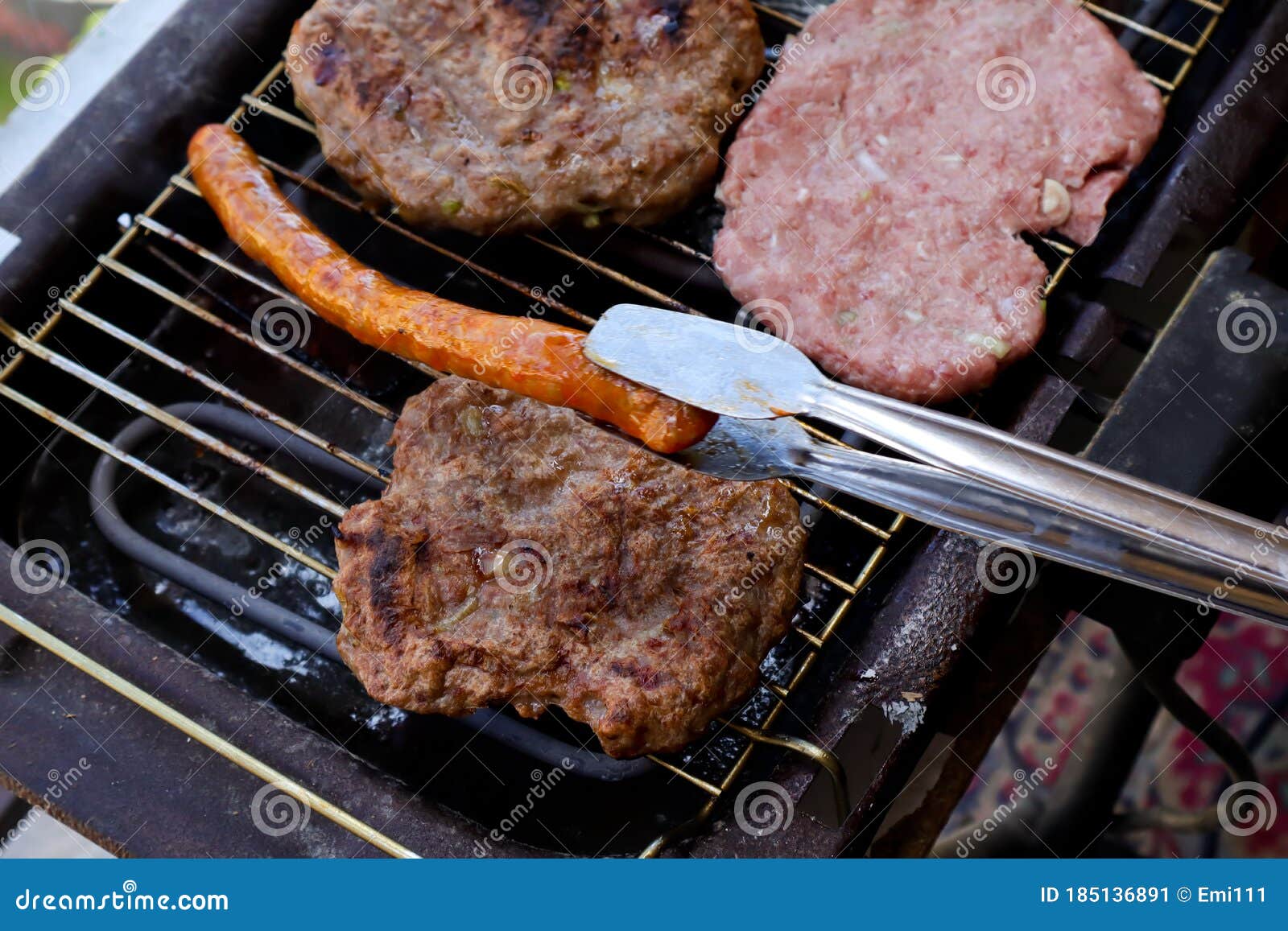 traditional serbian barbecue rostilj  homemade sausages and burgers. preparing a barbecue on a grill, barbecue tong,outdoor roas