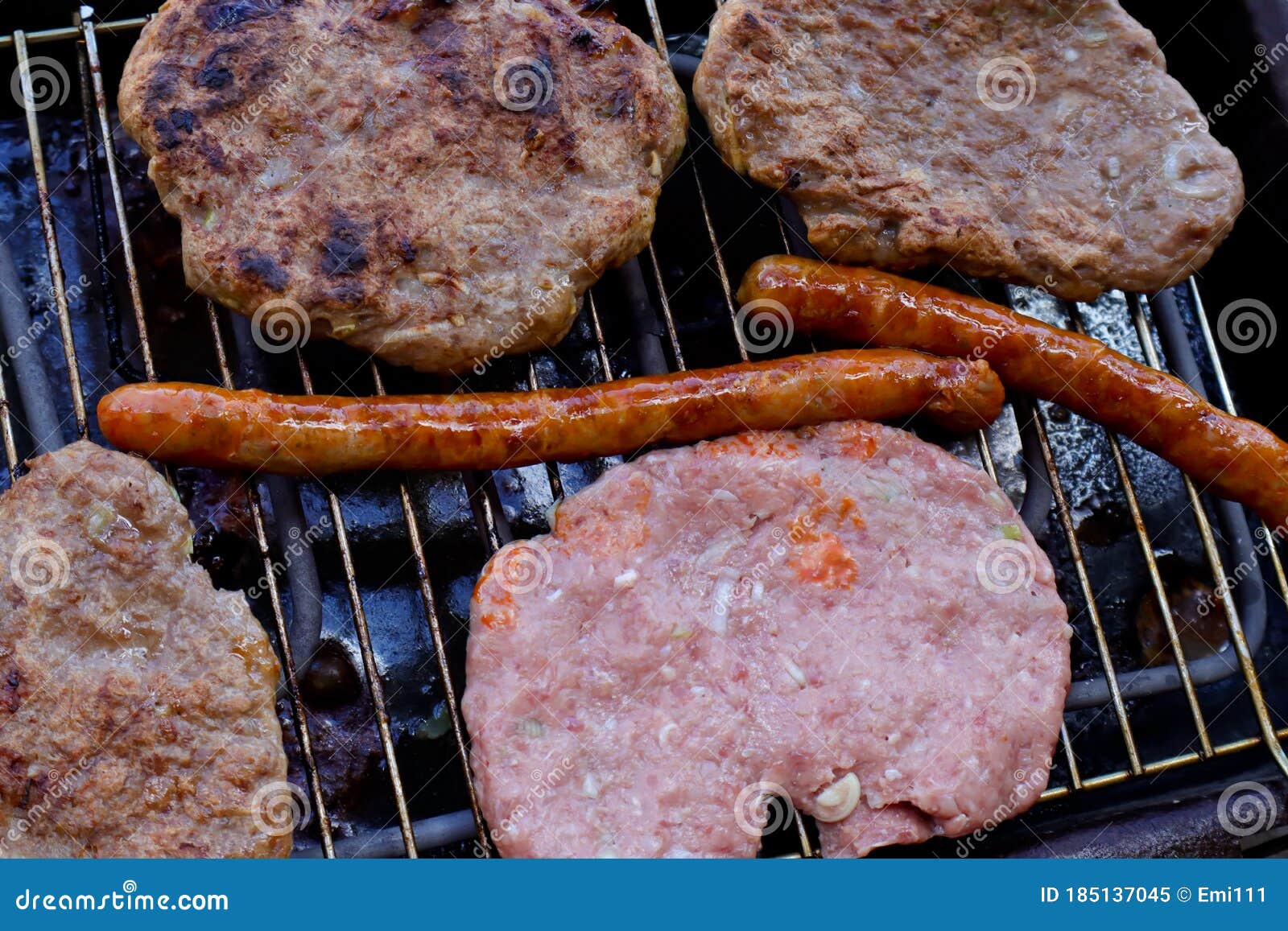 traditional serbian barbecue rostilj  homemade sausages and burgers. preparing a barbecue on a grill, outdoor roasting meat. tra