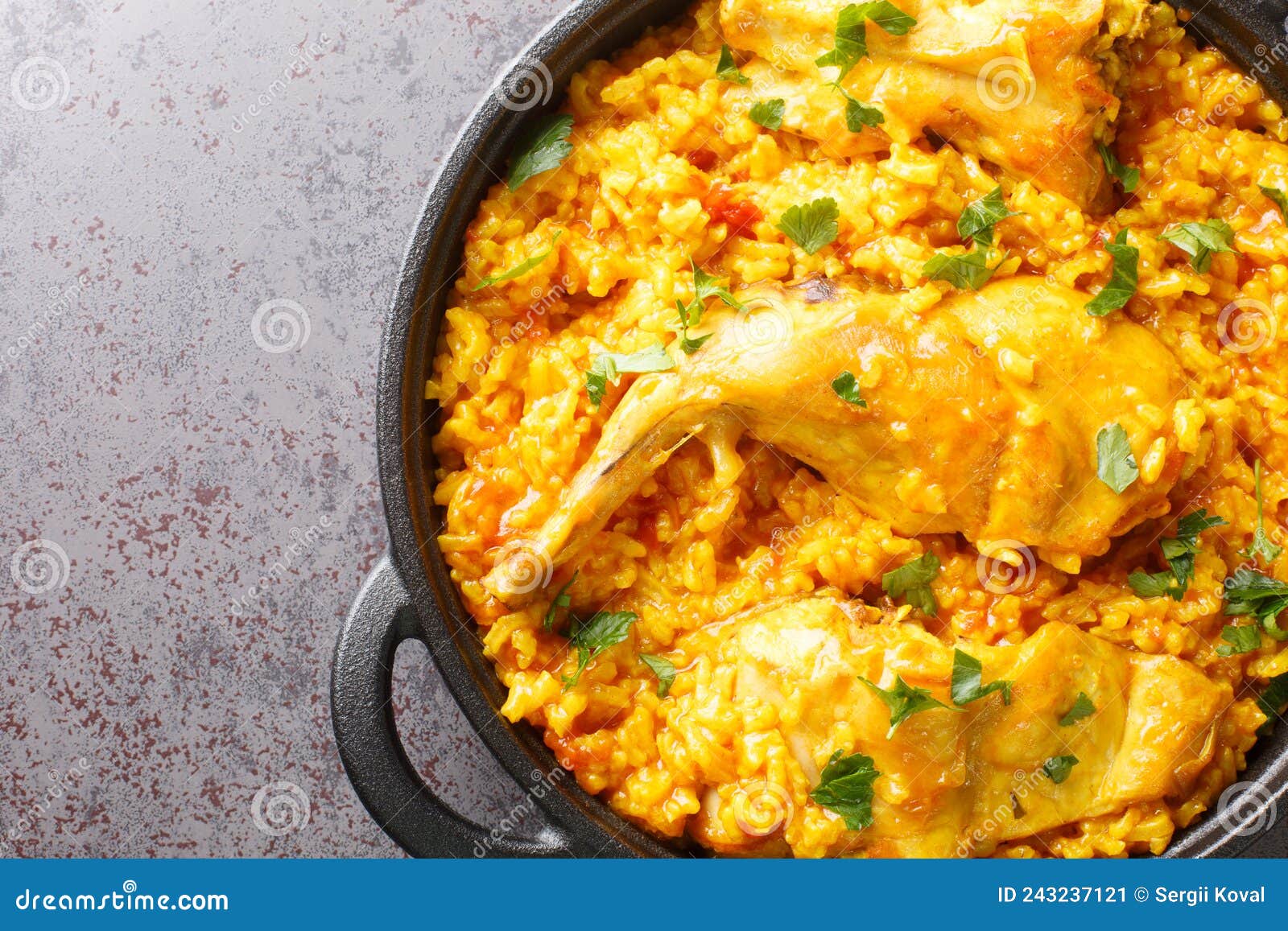 traditional spanish dish conejo con arroz that combines rice with rabbit meat closeup in the pan. horizontal top view
