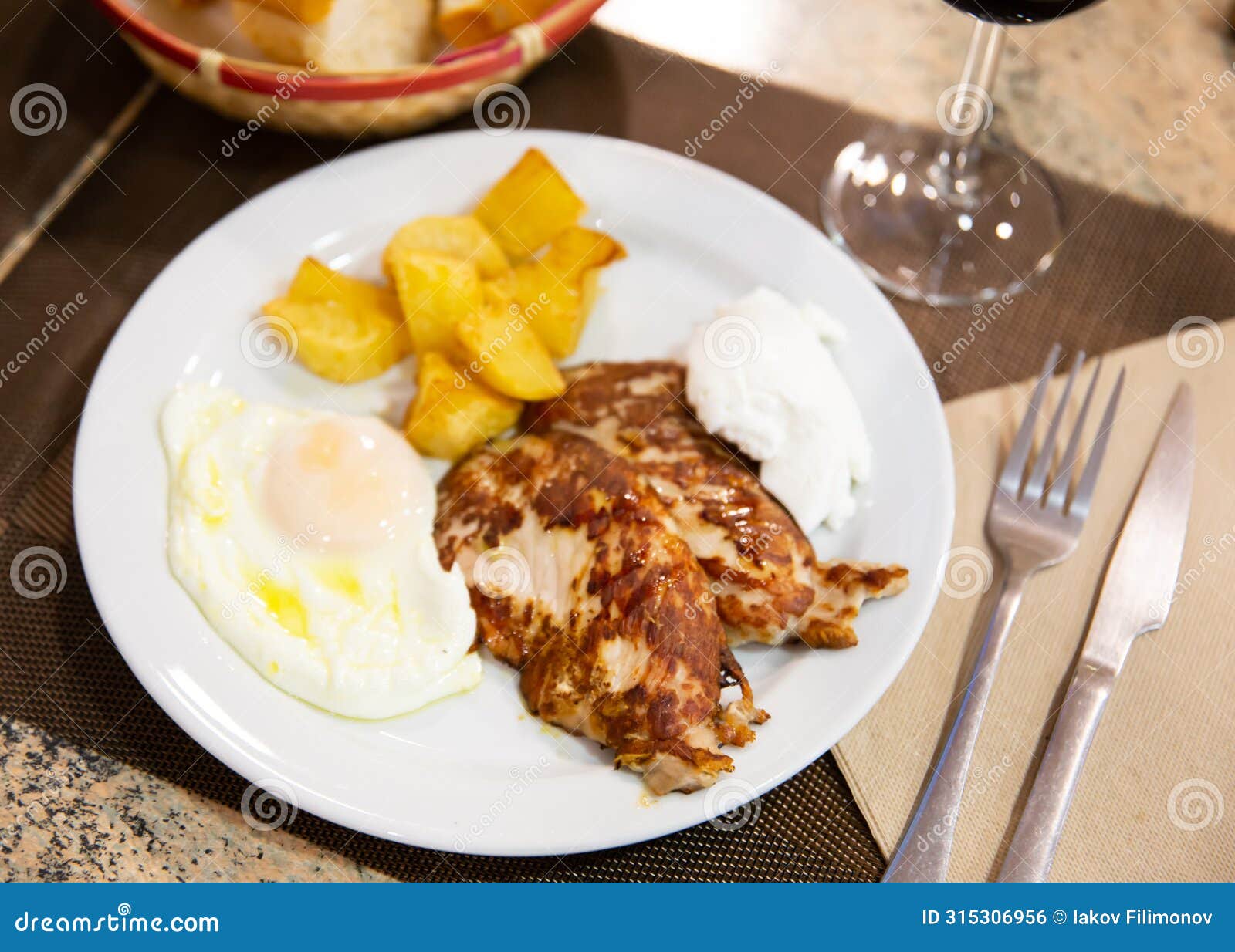 traditional spanish fried pork with potato and egg on plate. cerdo patata eggs