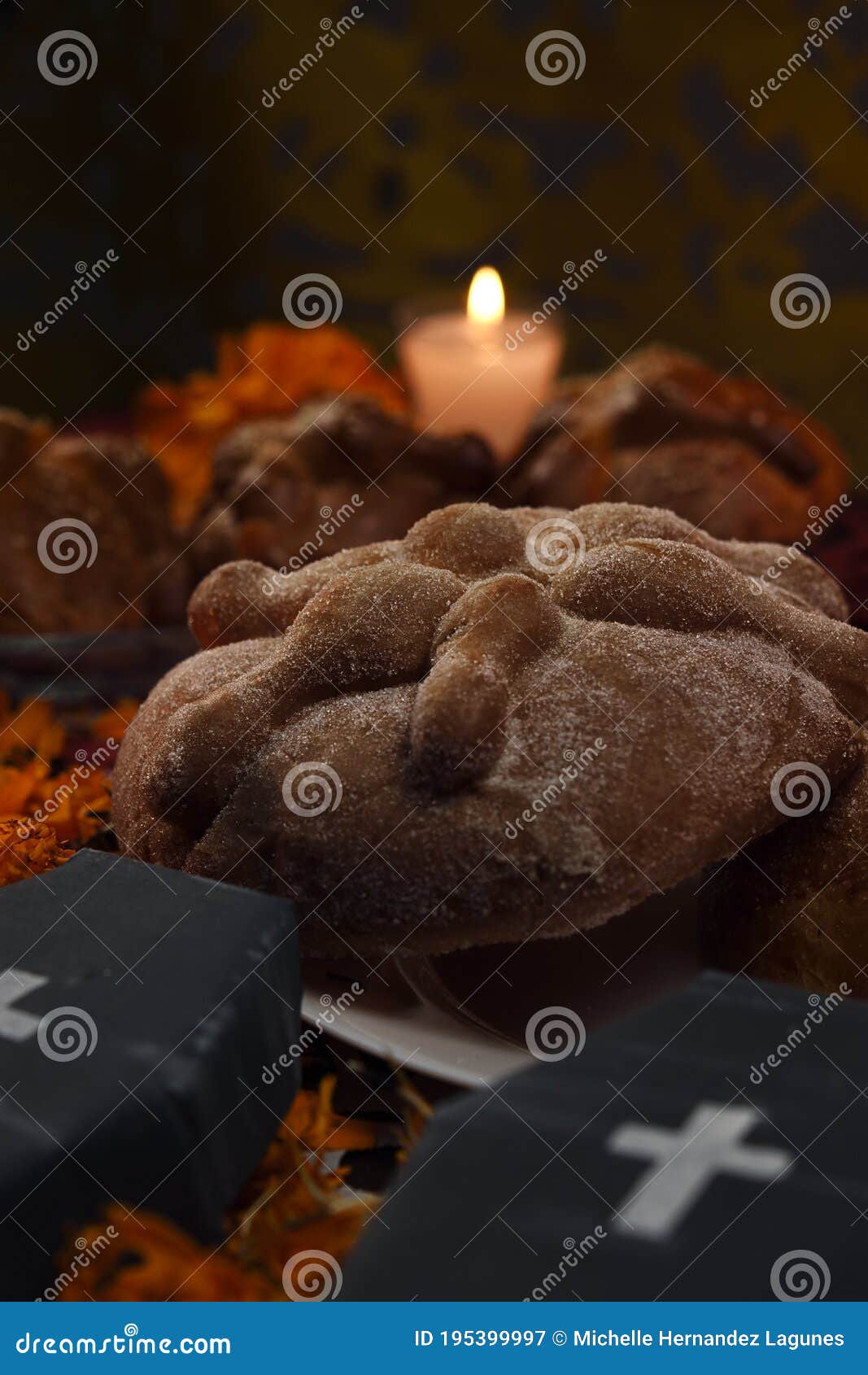 traditional sugary dead bread celebrating dia de muertos and using cempasuchienlt flowers, two coffins all on one altar