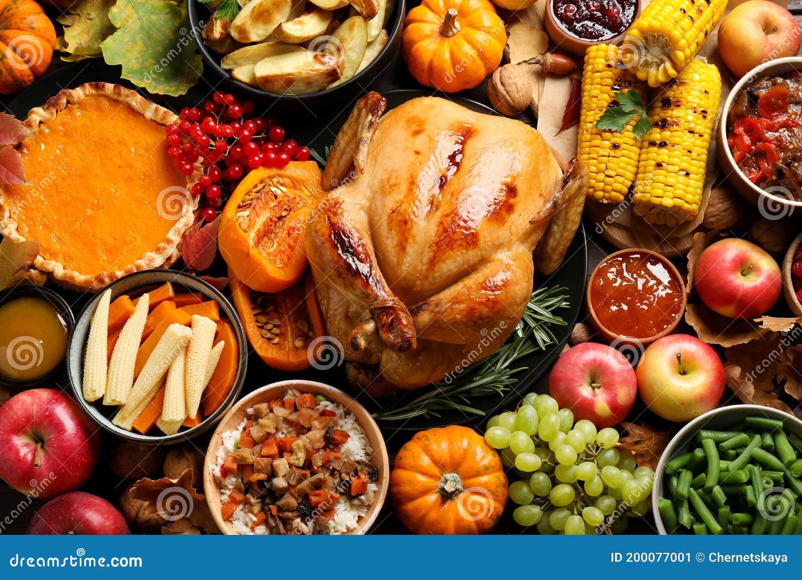 traditional thanksgiving day feast with delicious cooked turkey and other seasonal dishes as background, top view