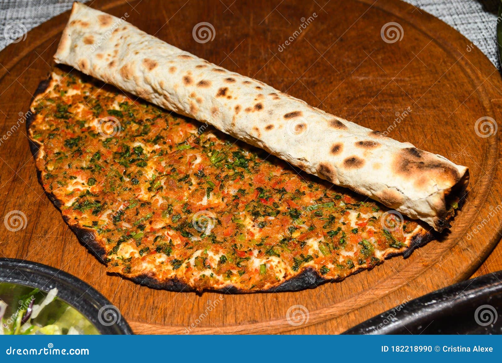 traditional turkish pizza, called lahmacun, being prepared with meat, onion and parsley