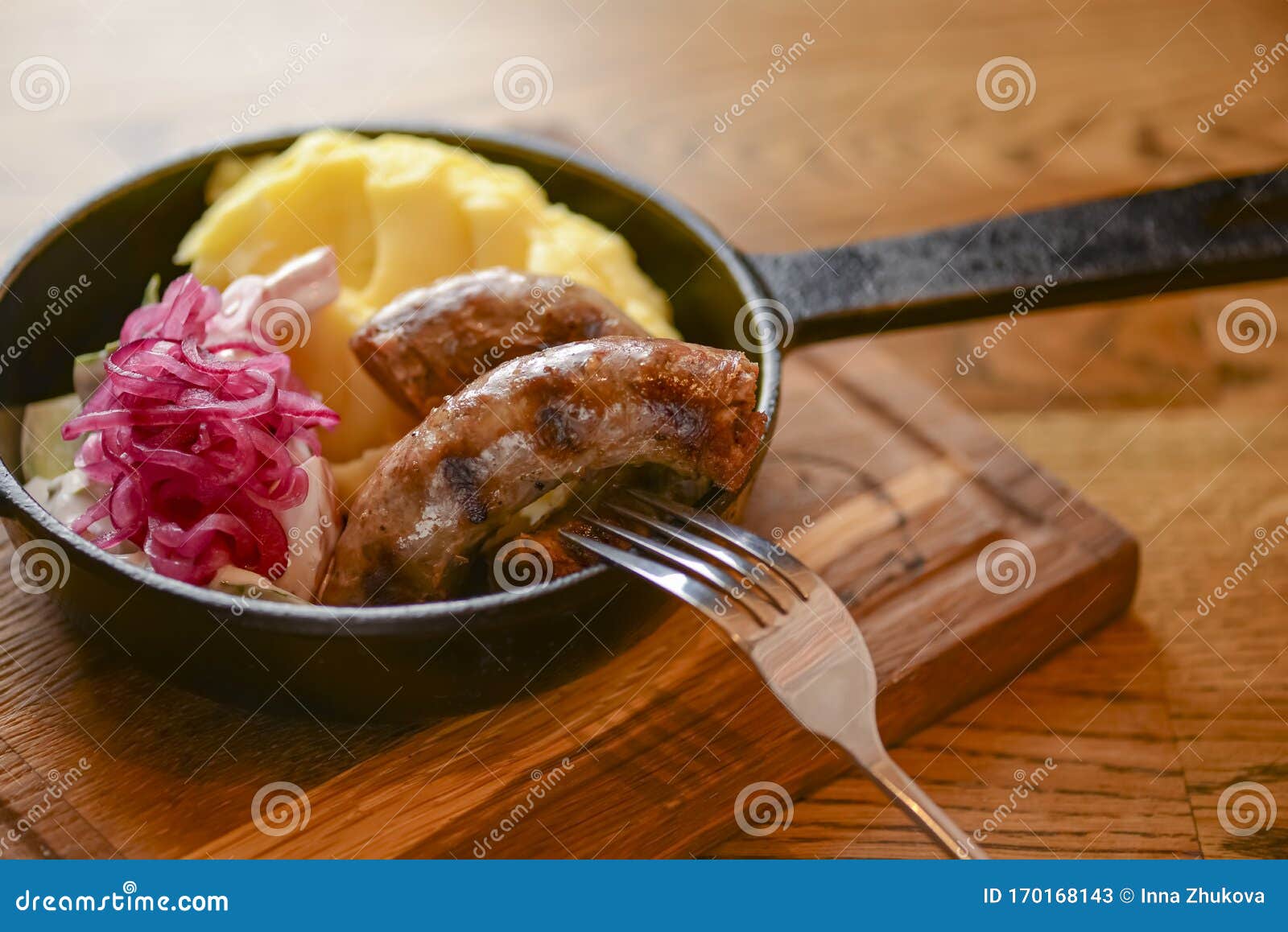 traditional ukrainian cuisine. pork sausages with mashed potatoes and cabagge salad served in a pan.