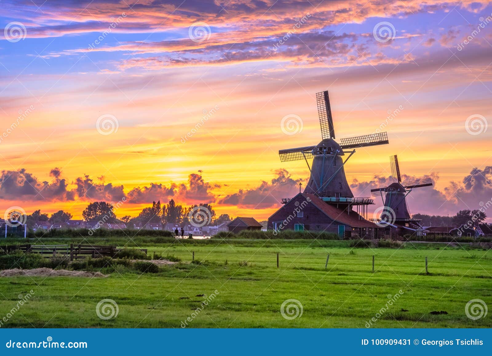 traditional village with dutch windmills and river at sunset, holland, netherlands.