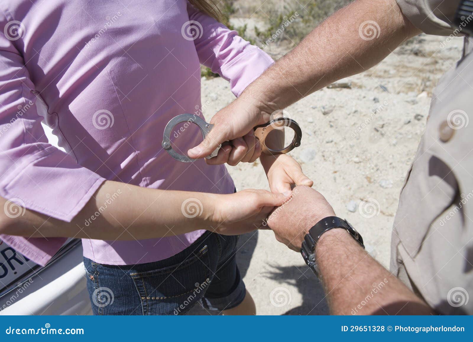 Police Officer Arresting A Woman With Handcuffs Stock