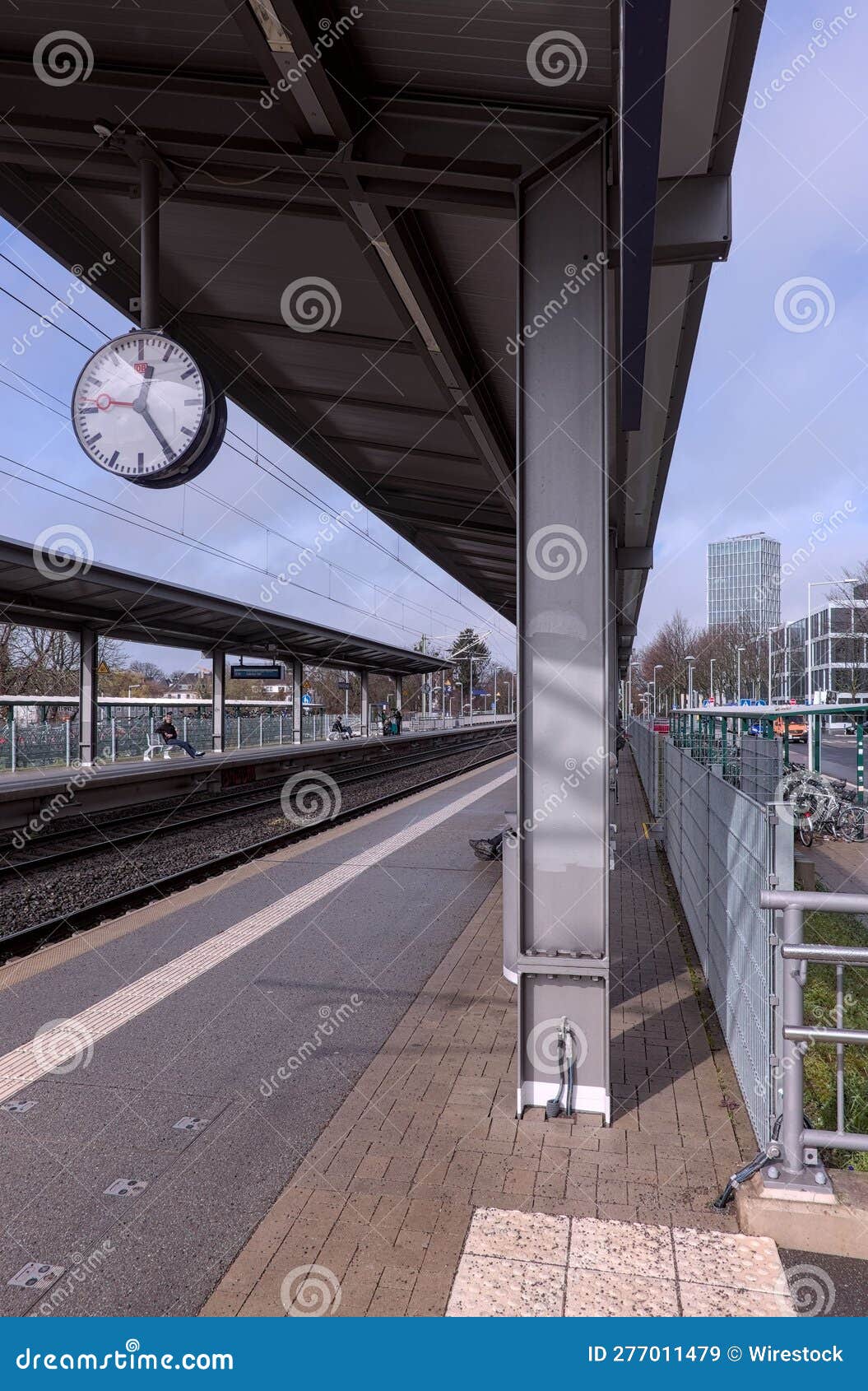 A Train Station Platform with a Clock Hanging on it S Side Editorial