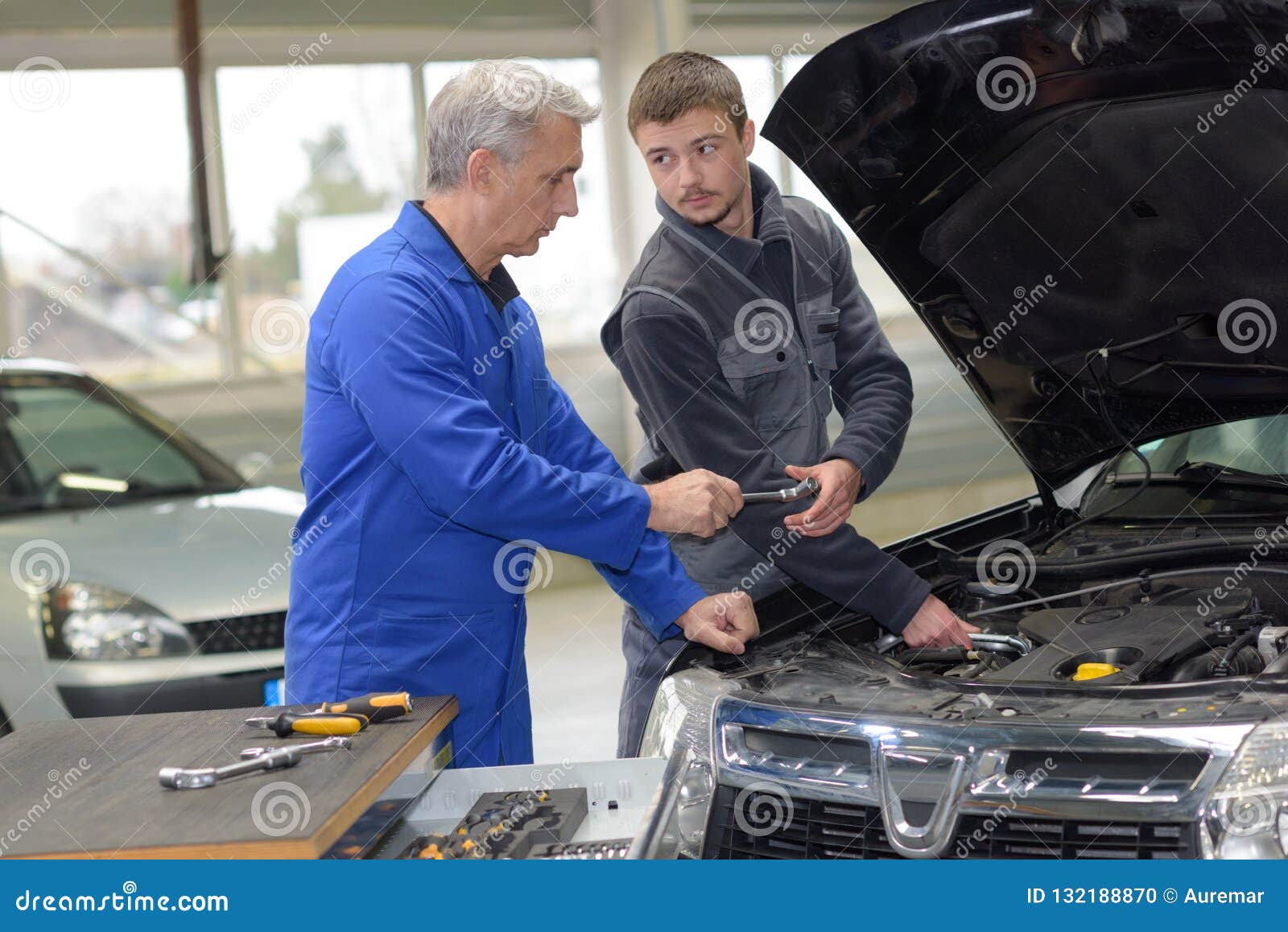 Trainee mechanic at work stock photo. Image of trainer 132188870