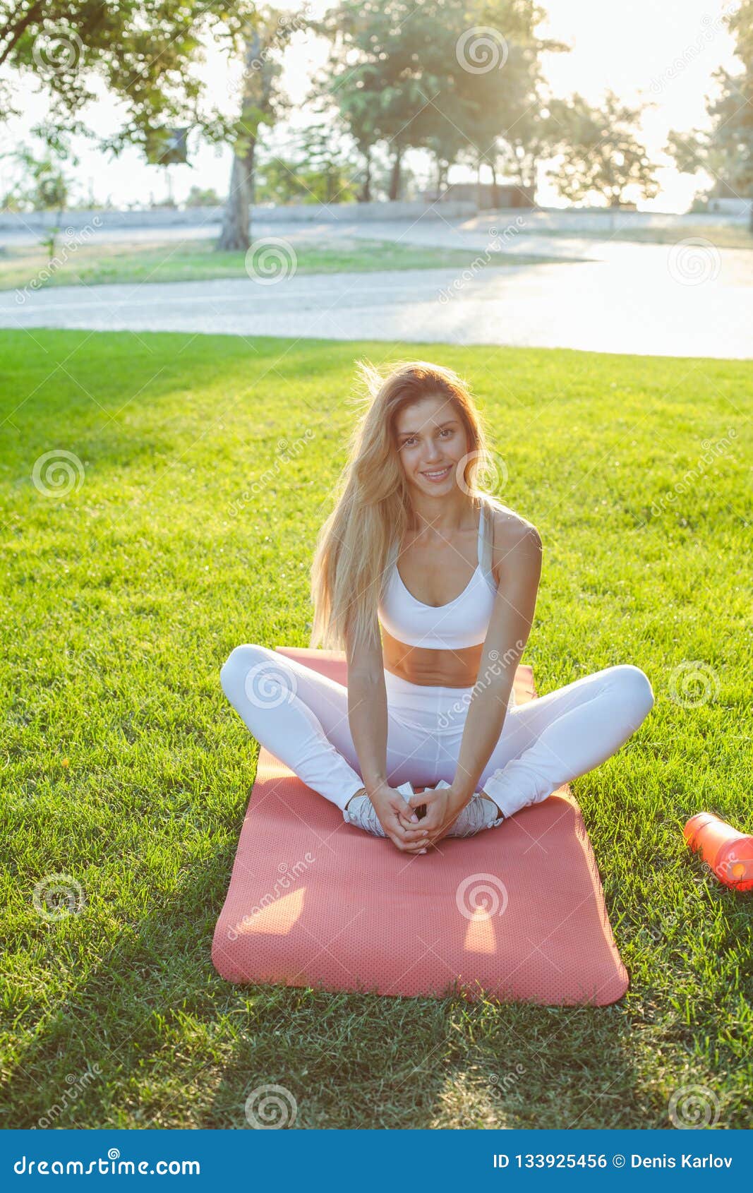 Training und Training im Freien. Sportmädchen, das auf einem Gras nach Übungen stationiert