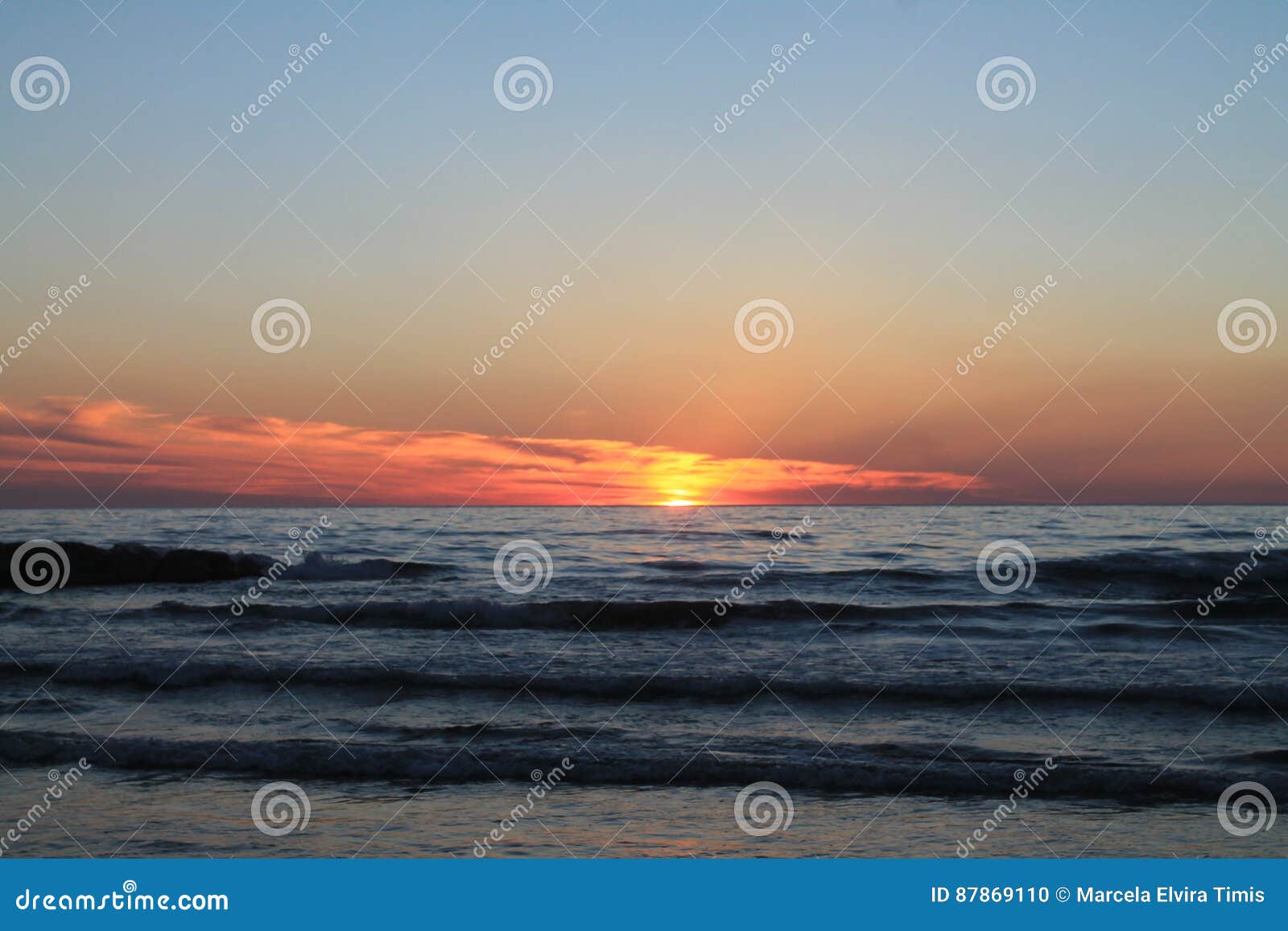 Tramonto. Il mar Mediterraneo al crepuscolo, con le onde basse, la luce solare è riflesso dalla superficie