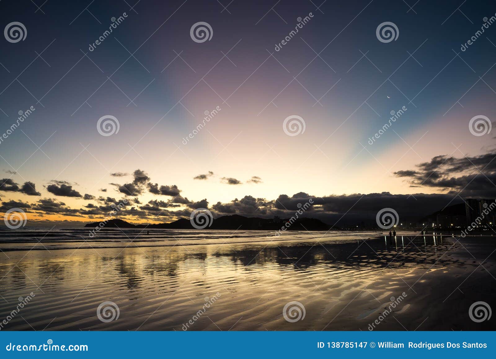 Tramonto in Santos con i raggi rosa e la luna crescente