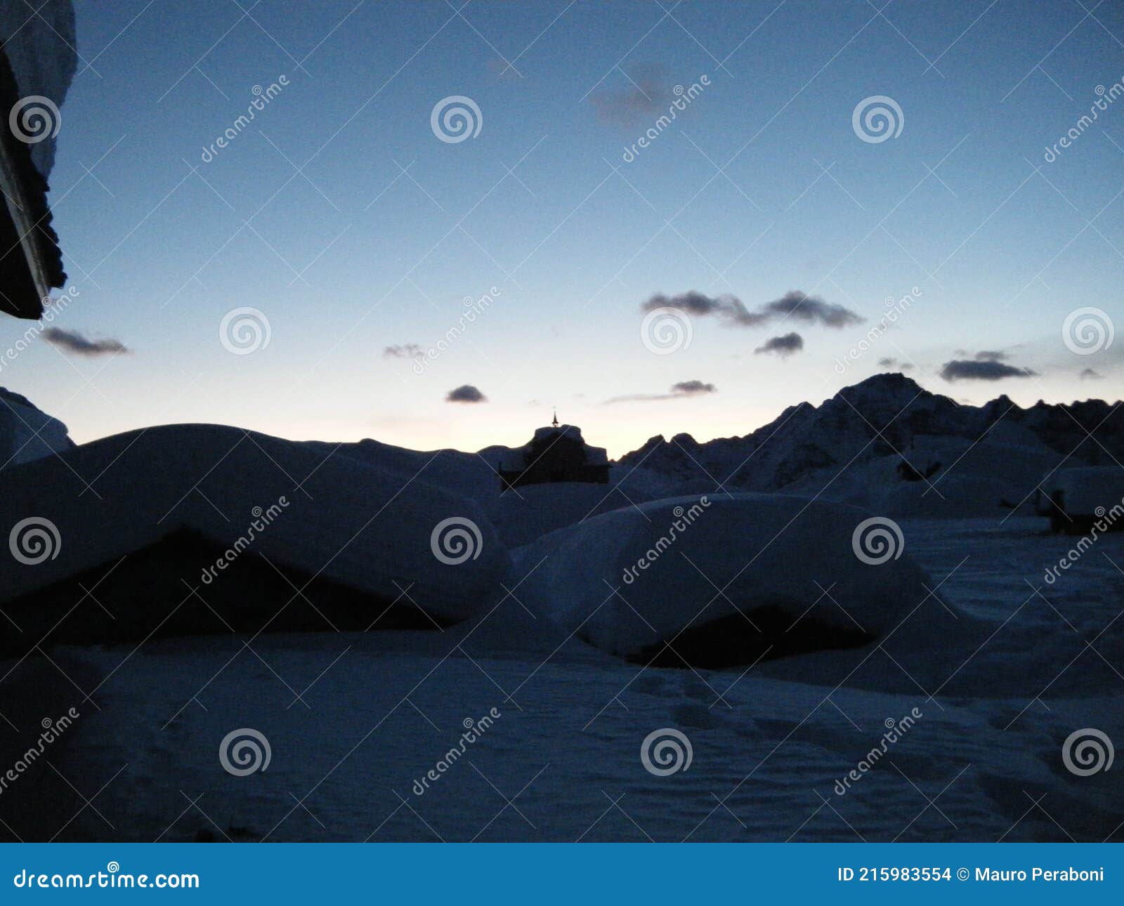 tramonto su tetti di baite innevati