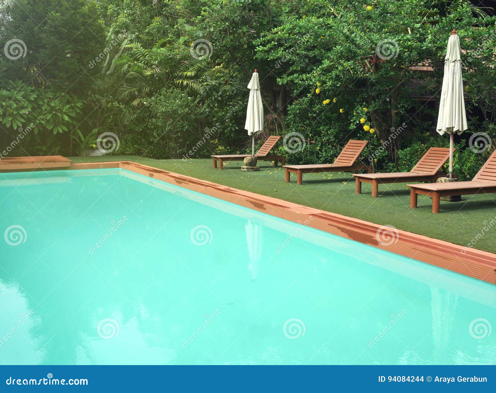 Tranquil Blue Pool In The Morning With Poolside Chairs And
