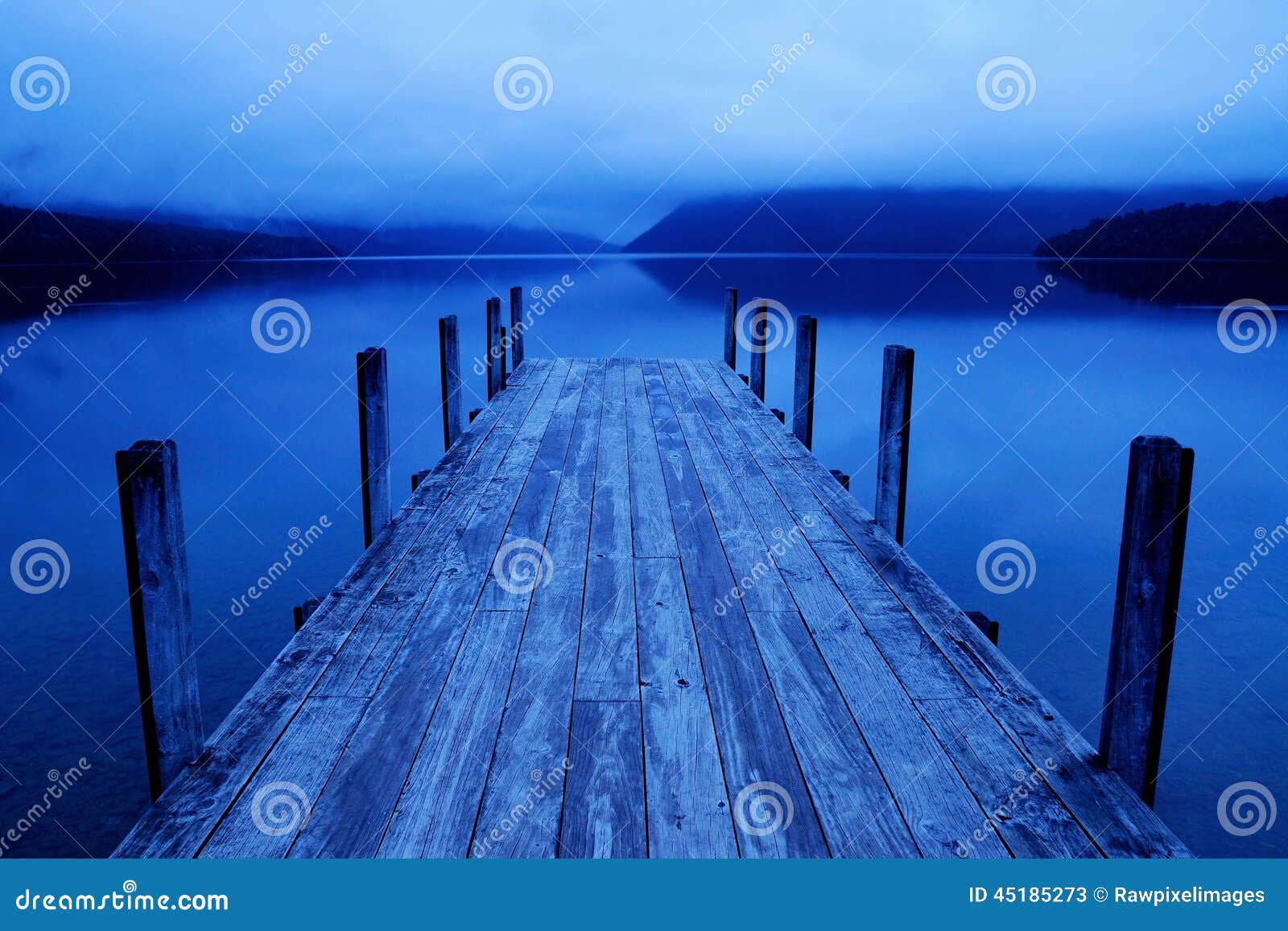 tranquil peaceful lake with blue jetty