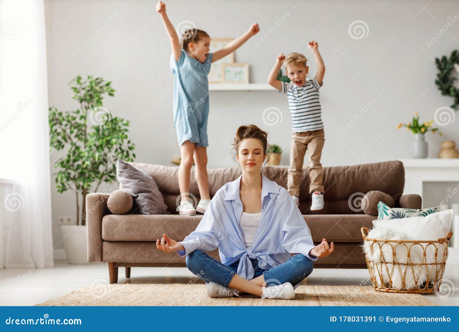 tranquil young mother practicing yoga to stay calm with mischievous kids at home