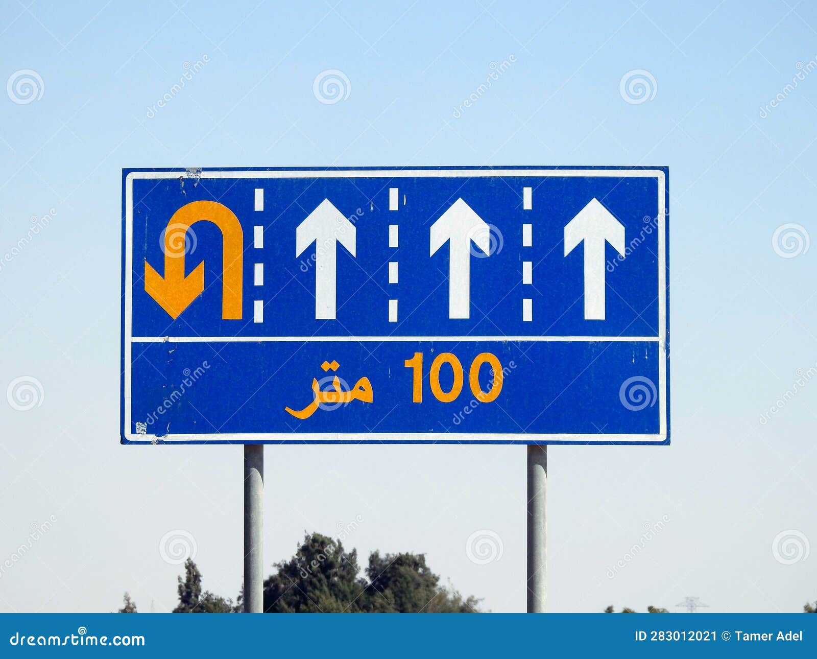 translation of the arabic (100 m one hundred meters) at a side informative traffic sign board showing 4 lanes