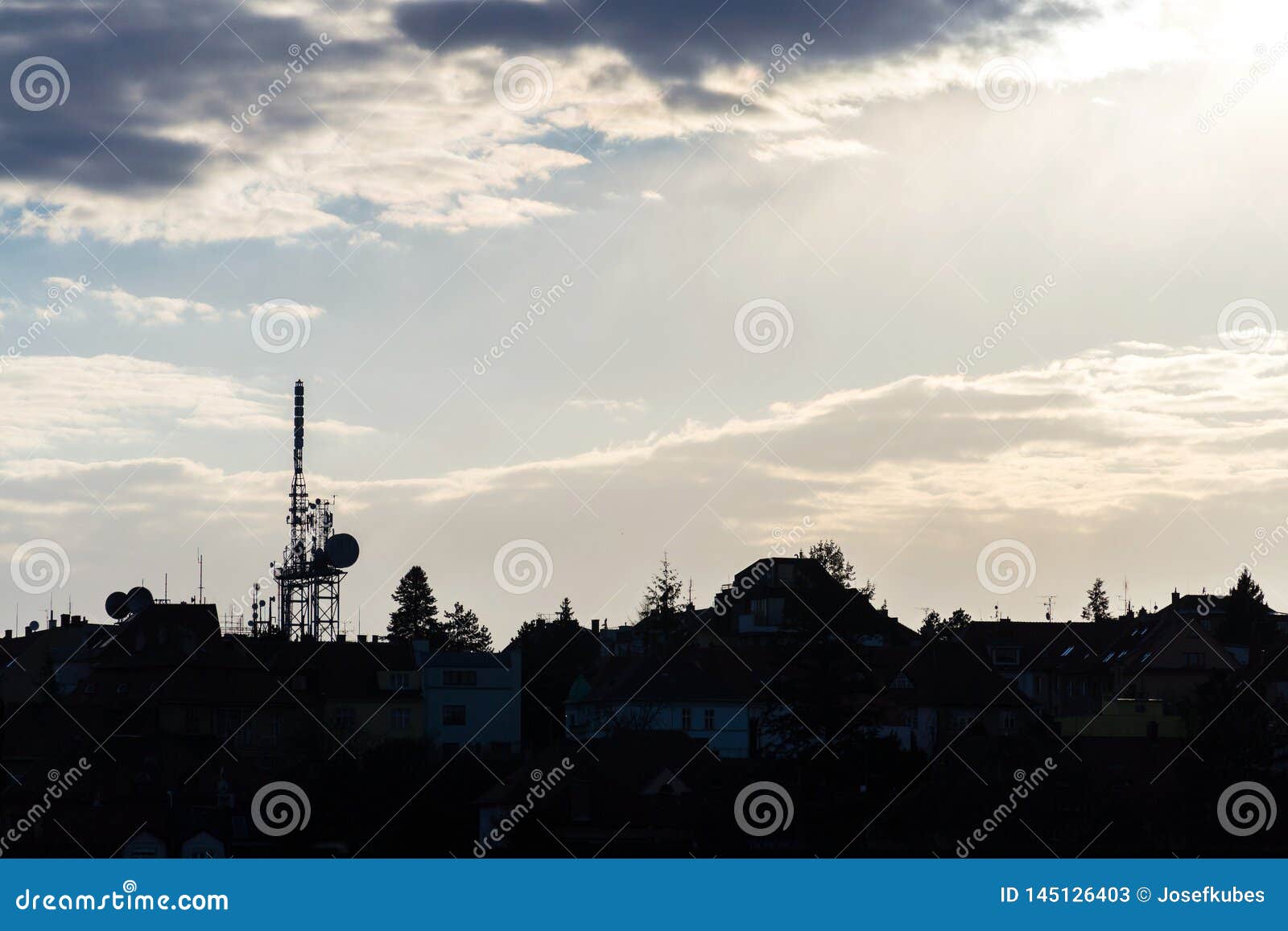 transmitters and aerials mobile telecommunication tower during beautiful sunset, dramatic cloudy sky with copy space