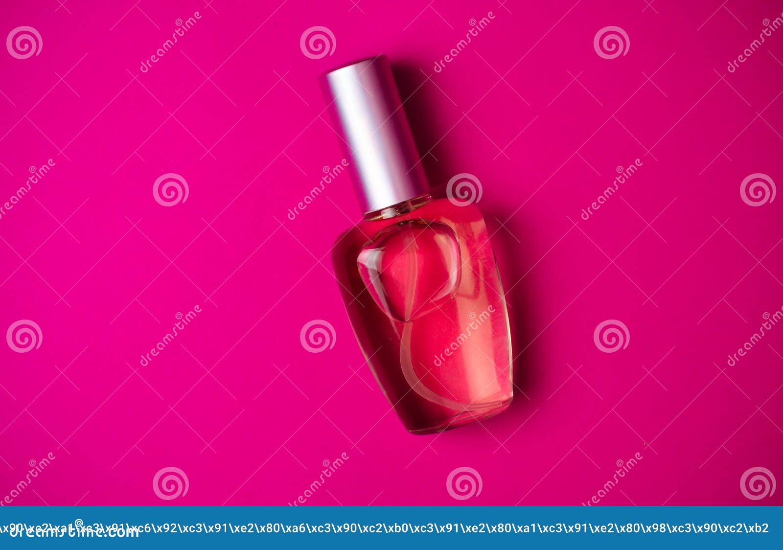 transparent bottle of female perfume on a colored pink background. top view. womenaccessories