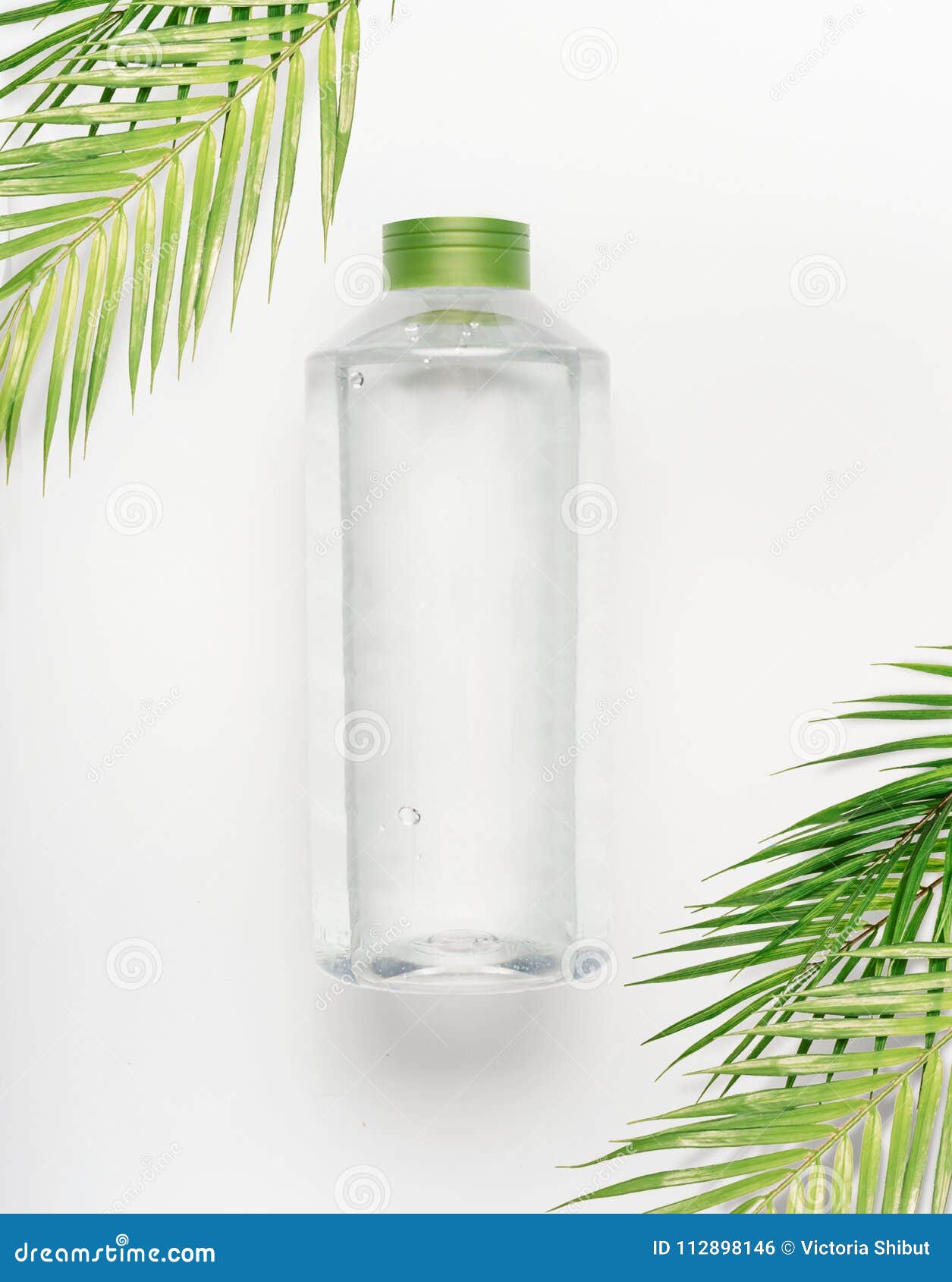 Transparent Liquid Bottle With Green Lid On White Desk Background