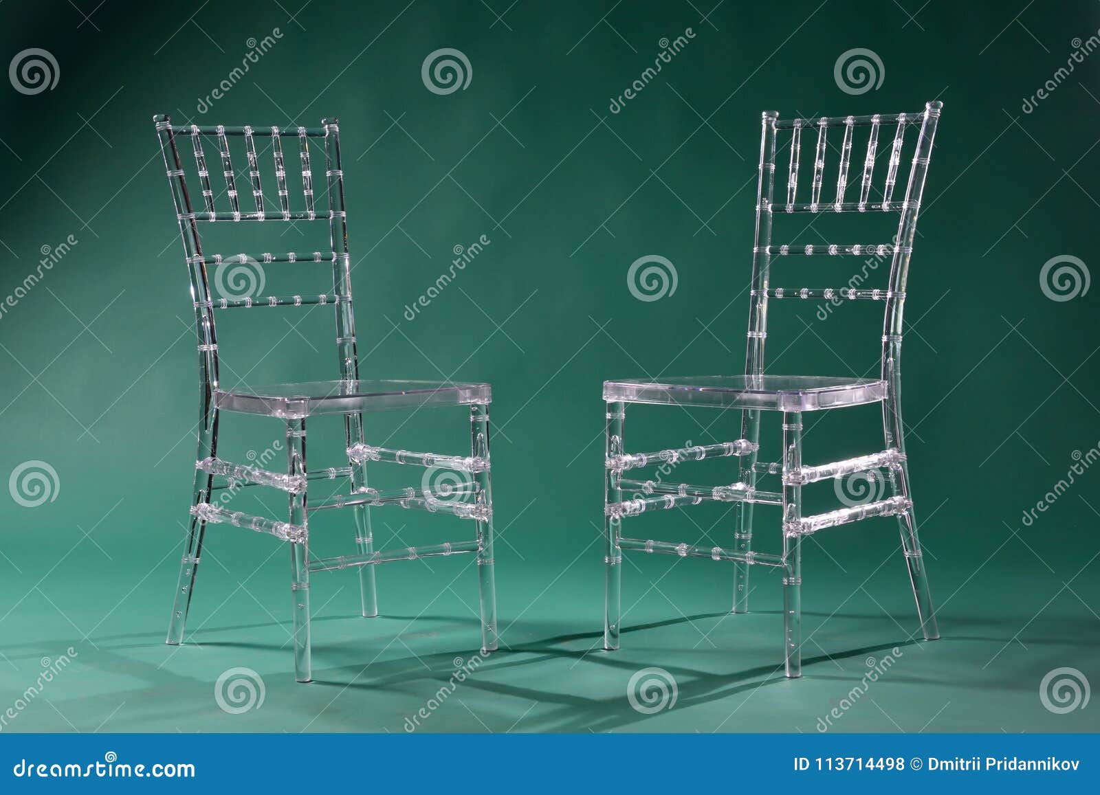 Transparent Plastic Chairs on a Green Background in a Photo Stud Stock