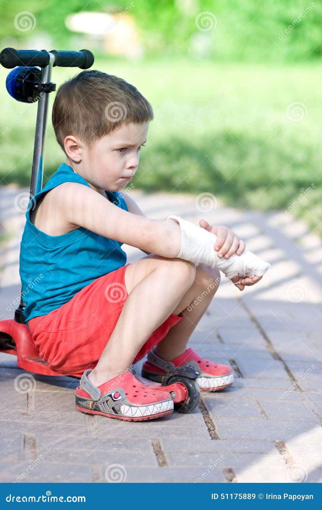 Trauriger Junge Mit Dem Gebrochenen Arm Sitzt Auf Roller Stockbild
