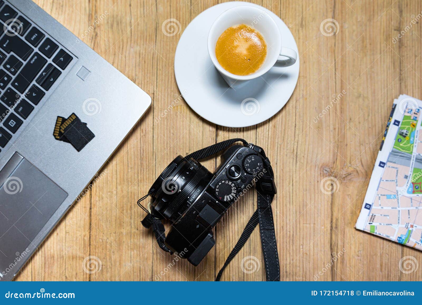 travel planning on wooden desk table with camera, laptop, memory cards and city map.